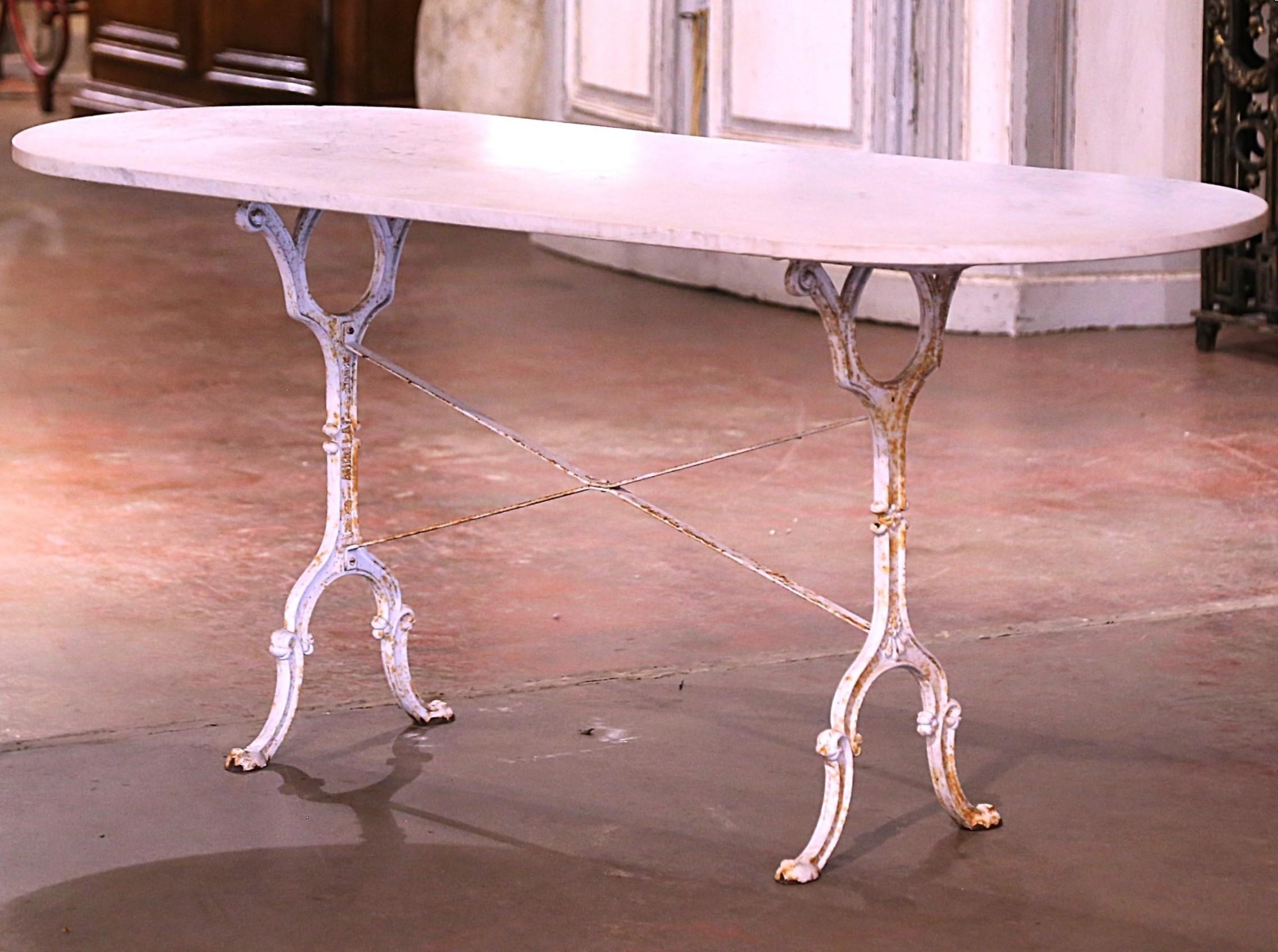 Decorate an outdoor patio or porch with this elegant antique bistrot table. Crafted in France circa 1930, the cast iron table sits on a trestle base with elegant scroll legs, and joined together with a double decorative crossed stretcher. The table