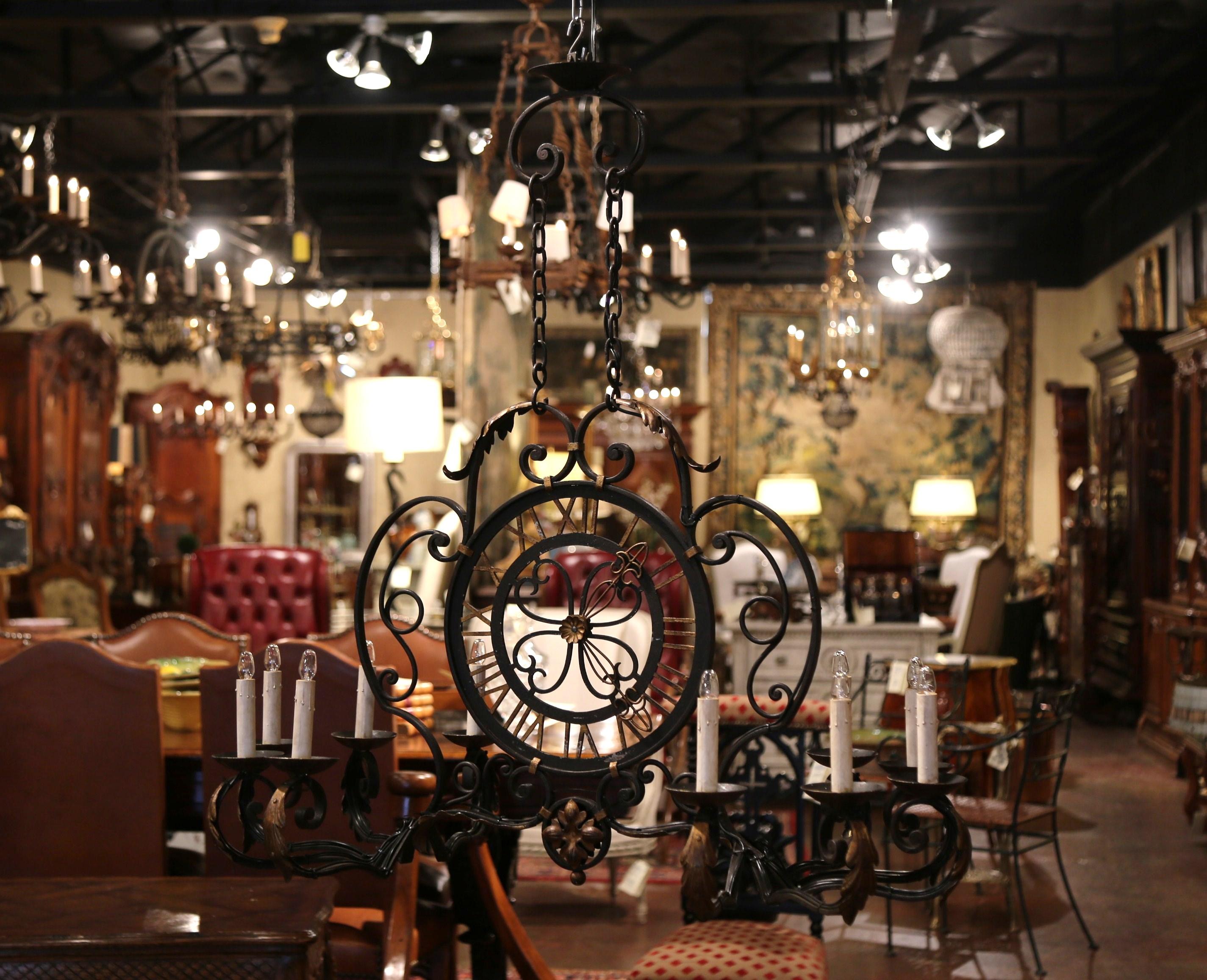 This elegant, antique chandelier was crafted in France, circa 1920. The large oblong iron fixture features ten newly wired lights with a center round metal clock with Roman numbers and stationary hands, embellished by decorative metal acanthus