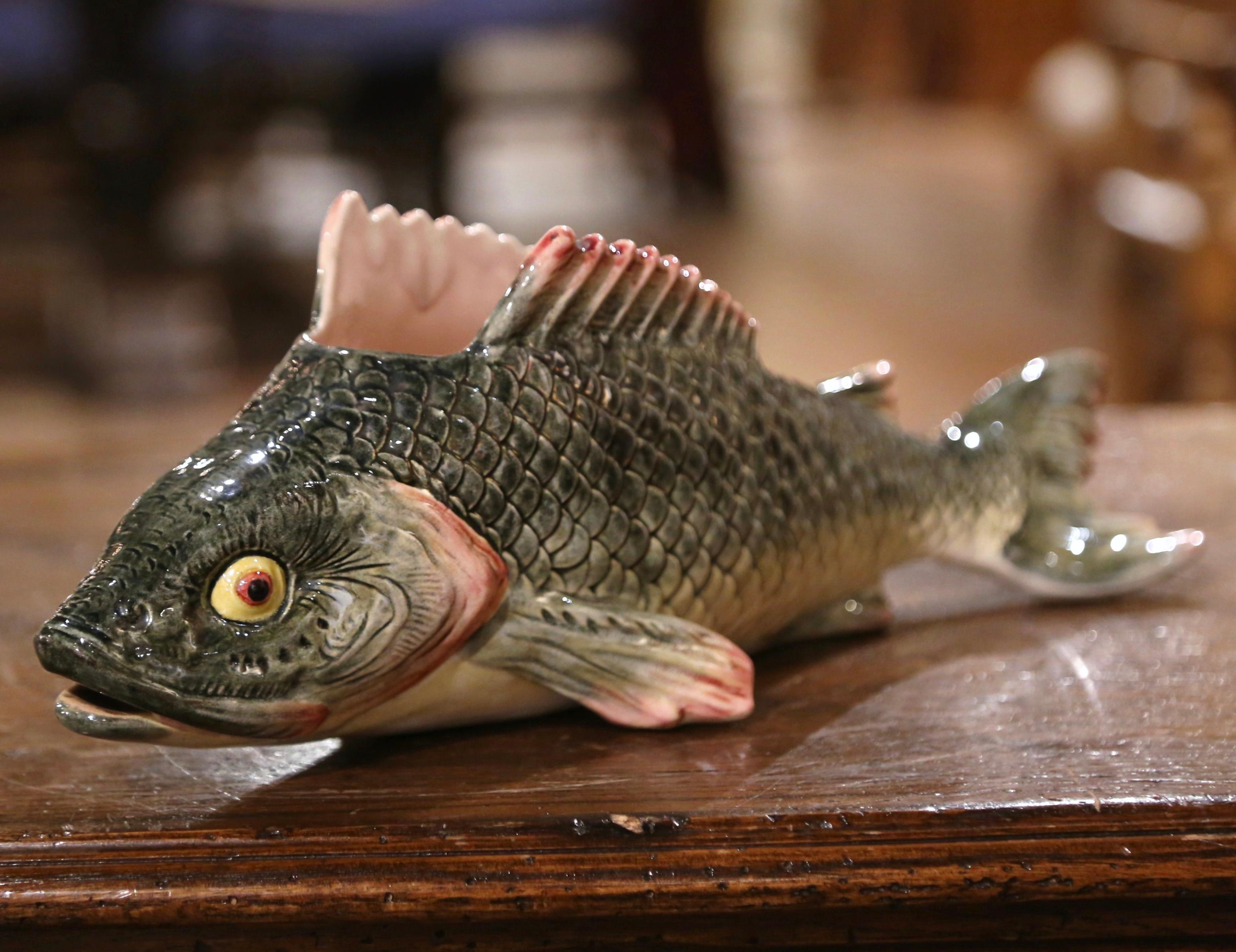 This lively antique figurine would make an interesting addition to any porcelain collection. The majolica fish container was sculpted in France, circa 1920 and is in the shape of a colorful rainbow trout laying flat with flippers extended. The