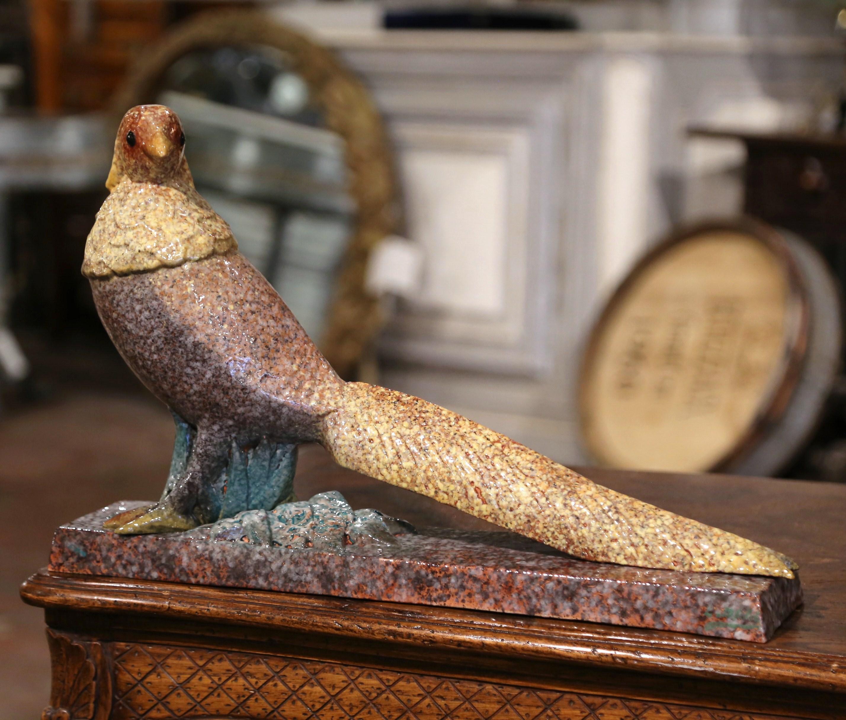 Decorate a ranch house, a hunting lodge or a man's office with this elegant and colorful antique bird sculpture. Crafted in France circa 1930 and built of ceramic, the sculpture depicts a proud pheasant resting on an integral rectangular base. The