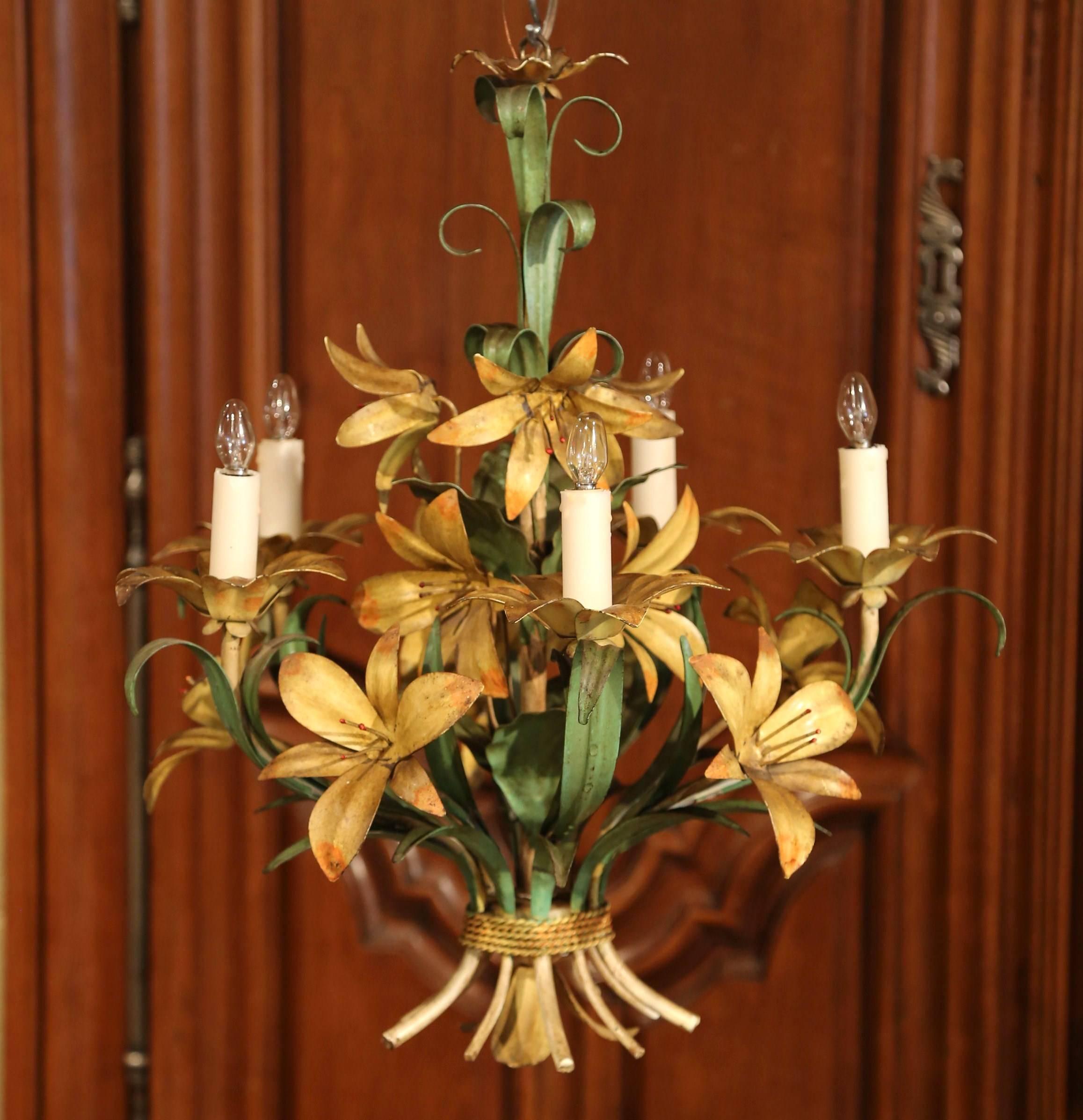 This elegant, antique chandelier was crafted in France, circa 1920. The small, charming hanging light fixture has five-light and is embellished with realistic orange lily flowers and green leaves. The round chandelier is in excellent condition and