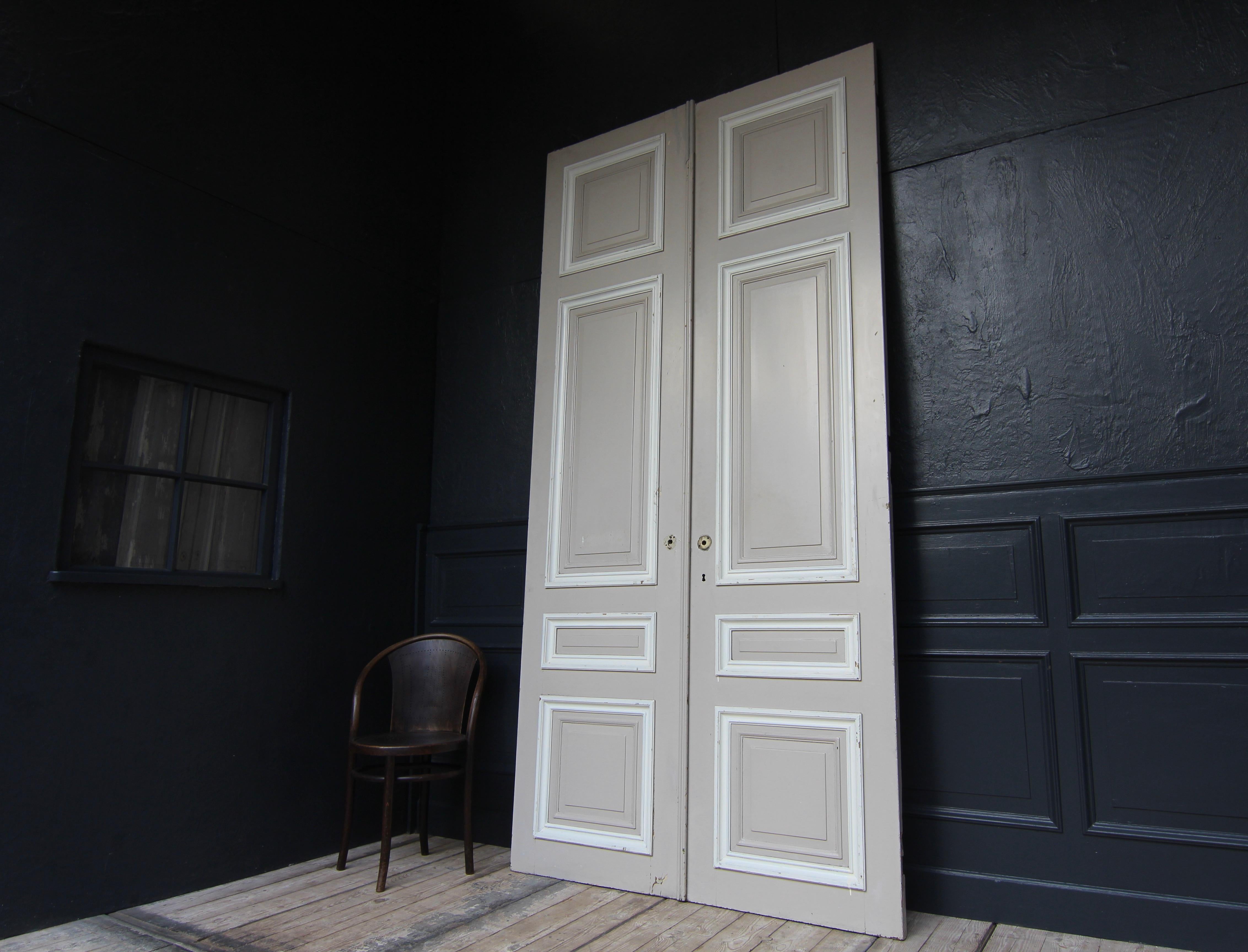 Tall French double door from the 1st half of the 20th century. Made of oak and painted. Unrestored condition.

Double door in frame construction with 4 coffered panels each.

One side in a taupe-like colour, the other side in an old cream