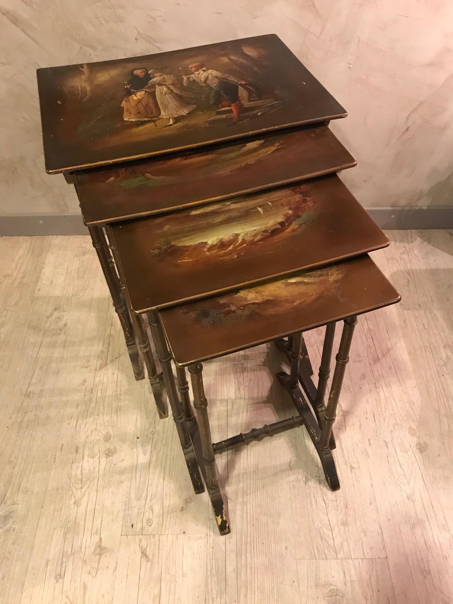 Very nice and original 20th century French painting nesting tables from the 1900s. 
Four nesting tables with each a different painting, on the biggest one we can see two women walking and a men with a magnifying glass, very romantique scene. 
The