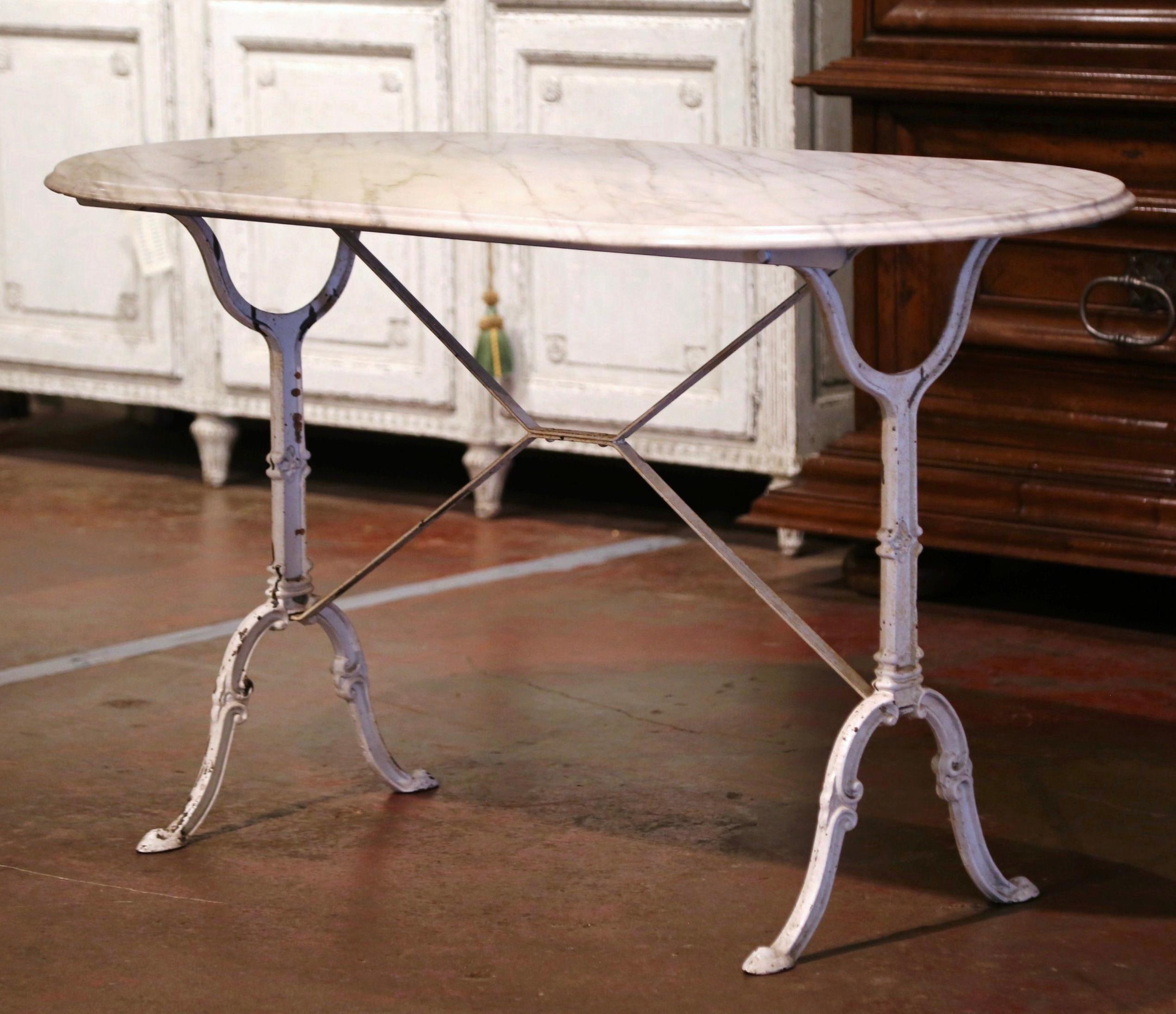 Bring the beauty of Paris into your home with this sophisticated antique pastry table. Crafted in France circa 1930, the table stands on two white painted iron pedestal legs connected with a center stretcher. The top is dressed with a racetrack