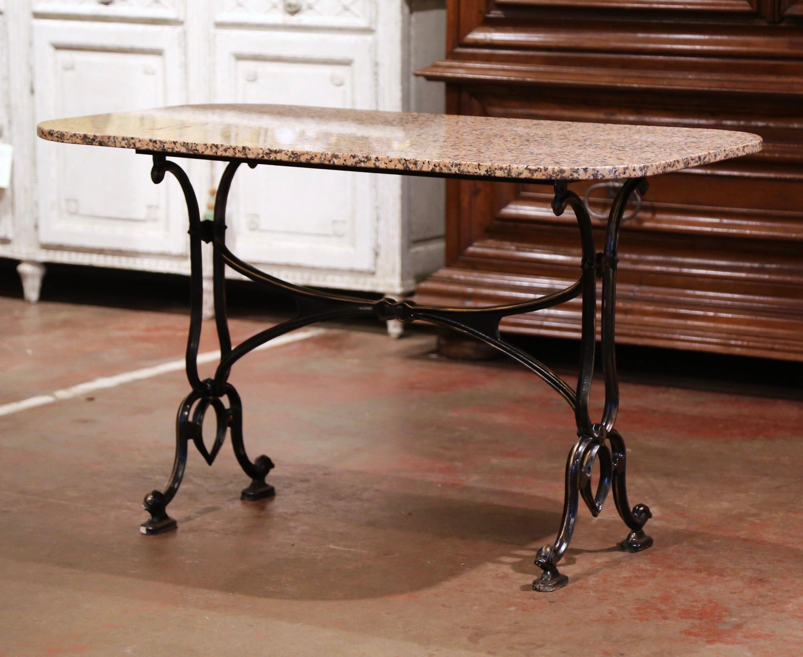 Crafted in Paris, France, and marked DAD, the antique cast iron table sits on a trestle base with elegant curved legs ending with scrolled feet, and joined with a double decorative stretcher. The sturdy iron base is dressed a rectangular variegated
