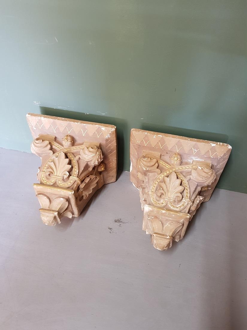 Set of 2 old French plaster wall consoles or brackets in a church architecture style and painted in a light brown color and finished with golden stripes, early 20th century. 

The measurements are,
Depth 34 cm/ 13.3 inch.
Width 38 cm/ 14.9