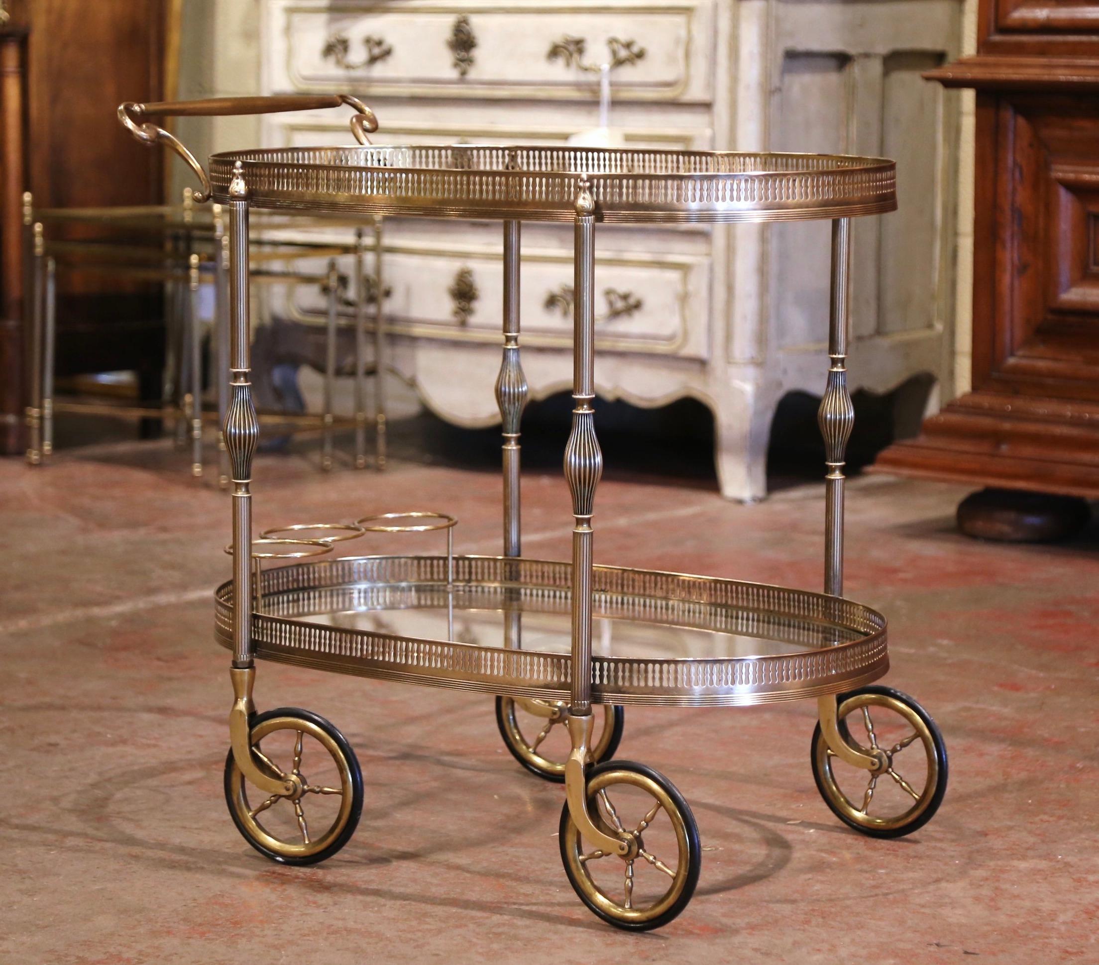 This beautiful, vintage rolling bar cart was created in France, circa 1930. Oval in shape and built of brass, the two-tier dessert table stands on four straight legs with top finials, decorated in the middle, and finished with small round wheels