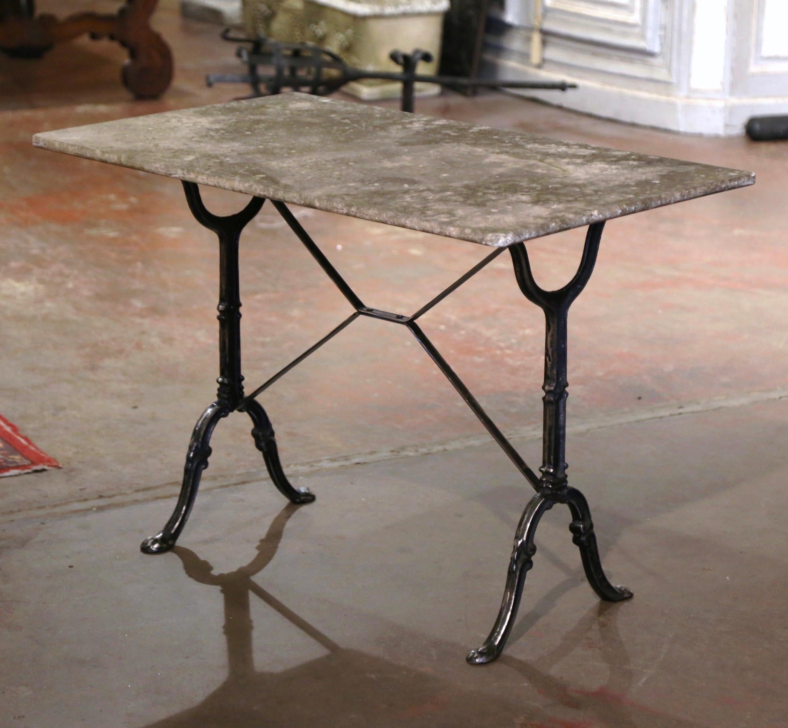 Decorate a patio or covered porch with this elegant antique bistrot table. Crafted in France circa 1920, the cast iron table sits on a trestle base with elegant scroll legs ending with hoof feet, and joined together with a double decorative