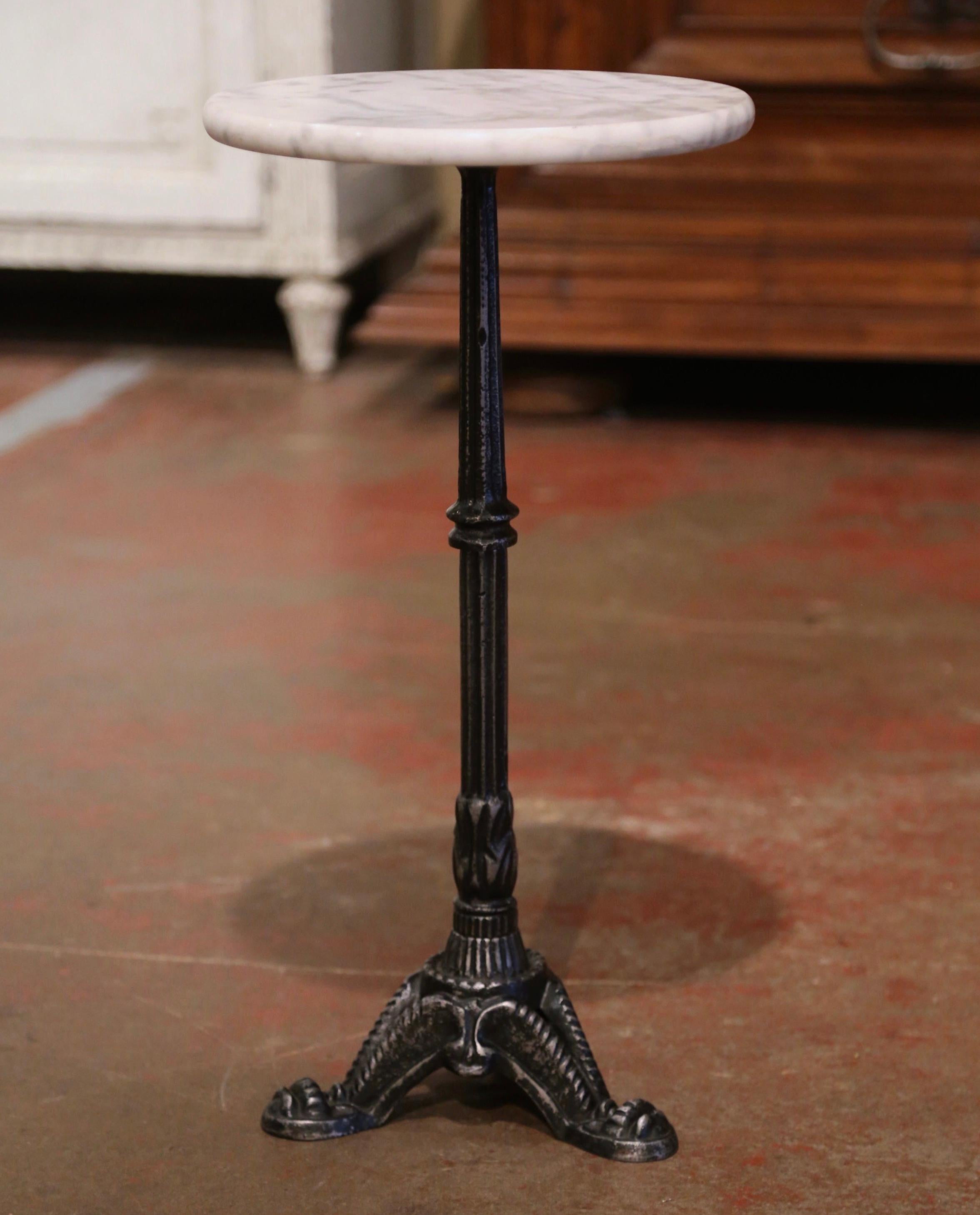 This elegant, antique round pedestal table was crafted in Southern France, circa 1920. The small end table sits on three curved legs ending with paw feet under a tapered and fluted pedestal stem. The side table is topped with a white and grey round