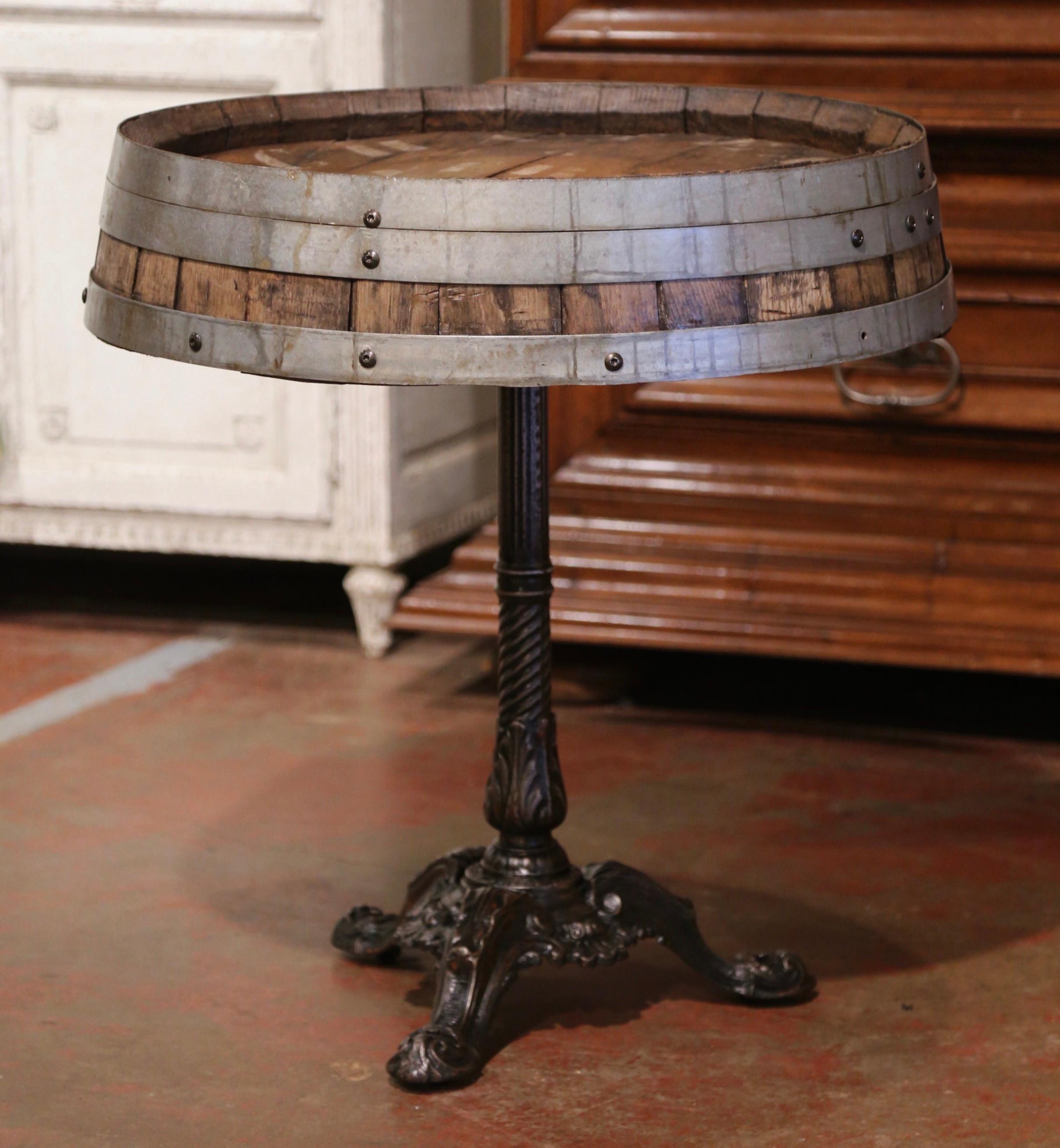 Decorate a wine cellar with this antique wine table. Created in the wine Bordeaux region of France, circa 1920, the table stands on a polished steel iron pedestal base with paw feet. The surface is a wine barrel top made of oak and strapped with the