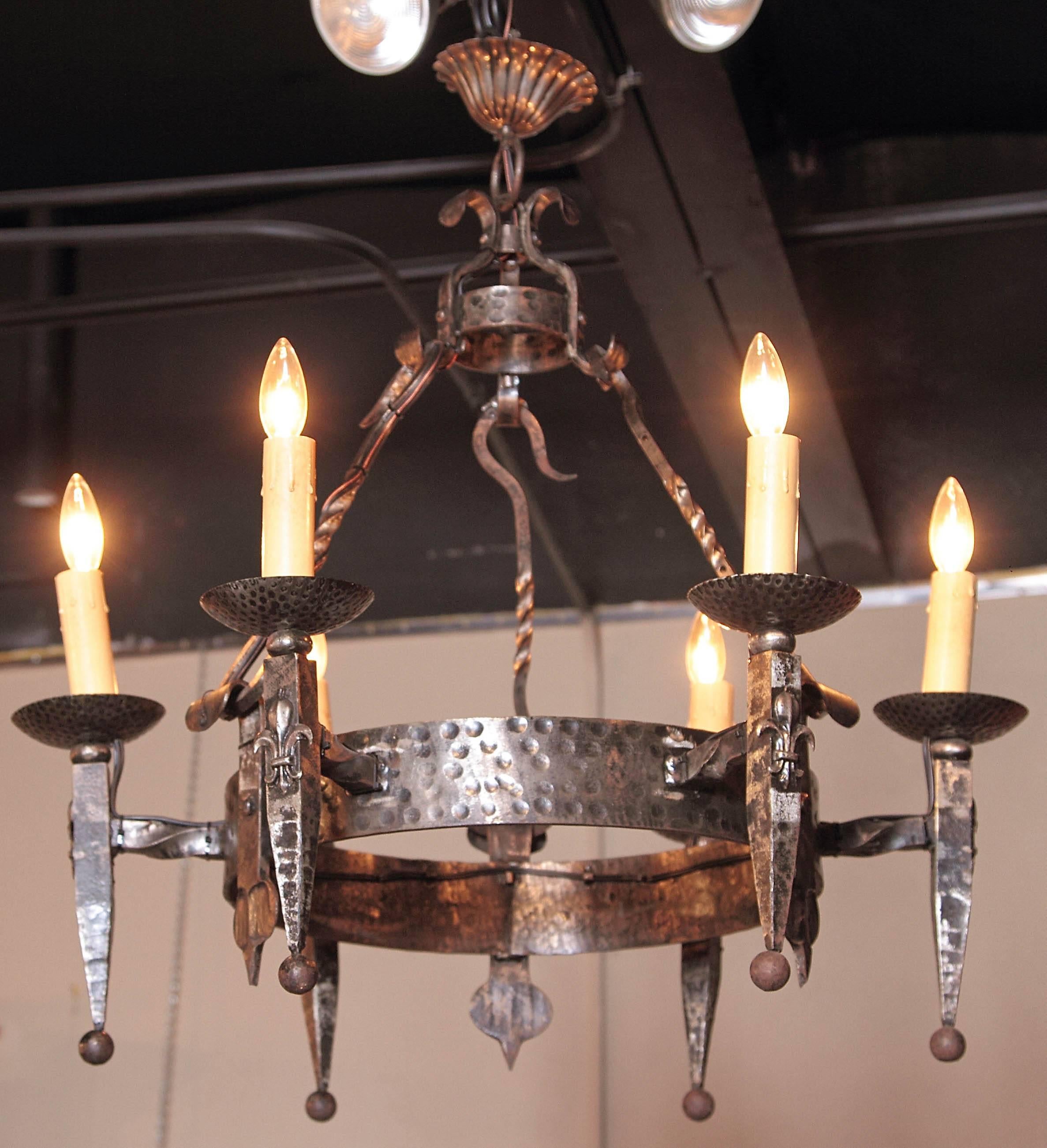 This elegant, Gothic chandelier was crafted in France, circa 1900. Round in shape and forged from wrought iron, the antique light fixture has six newly wired lights decorated with decorative candle sleeves; the overhead chandelier is embellished