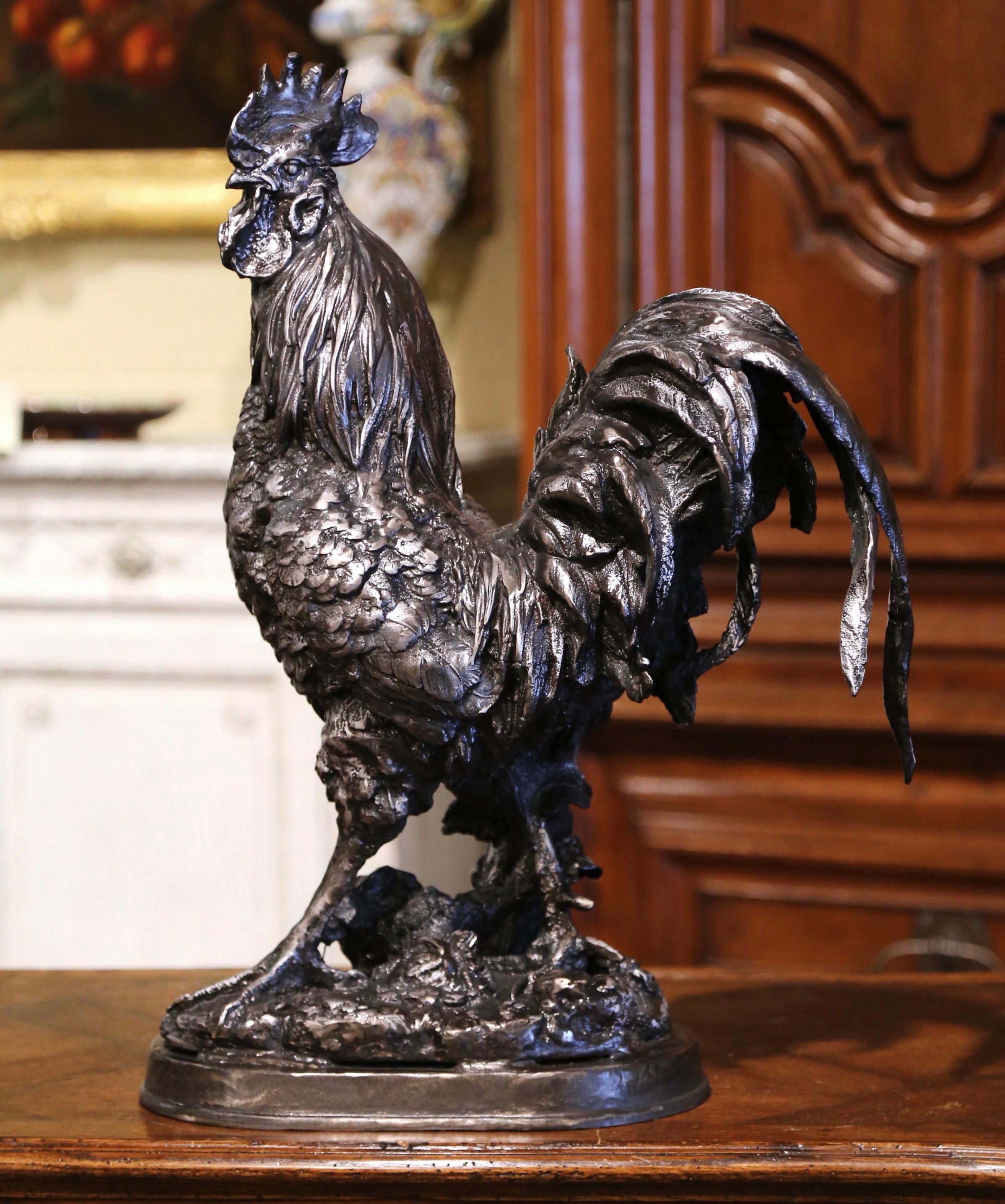 Decorate a kitchen counter with this important antique rooster. Crafted in France circa 1920 and made of solid iron, the sculpture stands on a rocky base and features wonderful details including the plumage. The elegant bird, symbol of France, is in