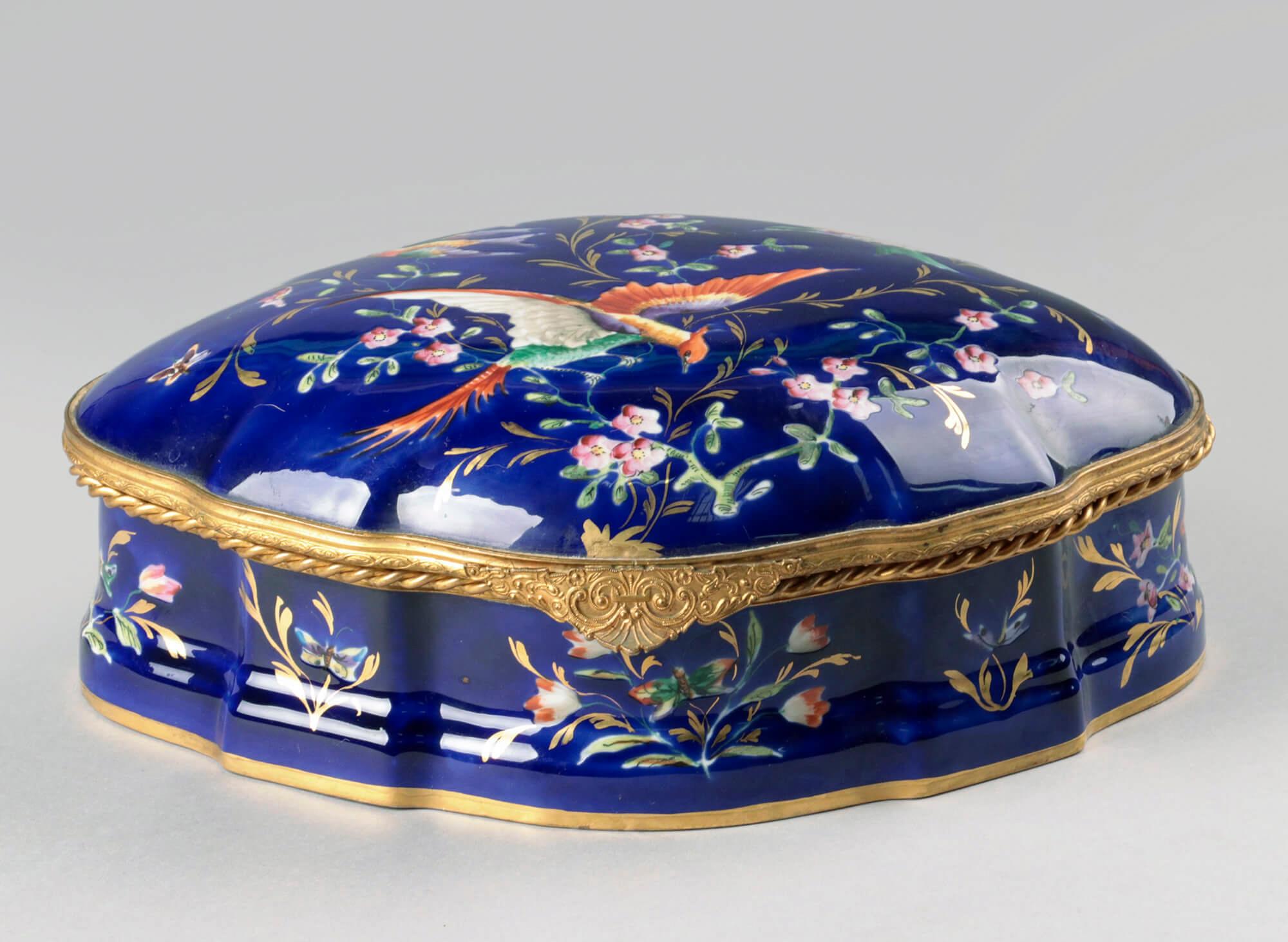 Beautiful antique chocolate box. Made of porcelain with a bronze mount. The box was commissioned by chocolate shop 'Marquise de Sevigne'. The inside of the box is also beautifully painted with gold decorations.
On the bottom of the box is a text