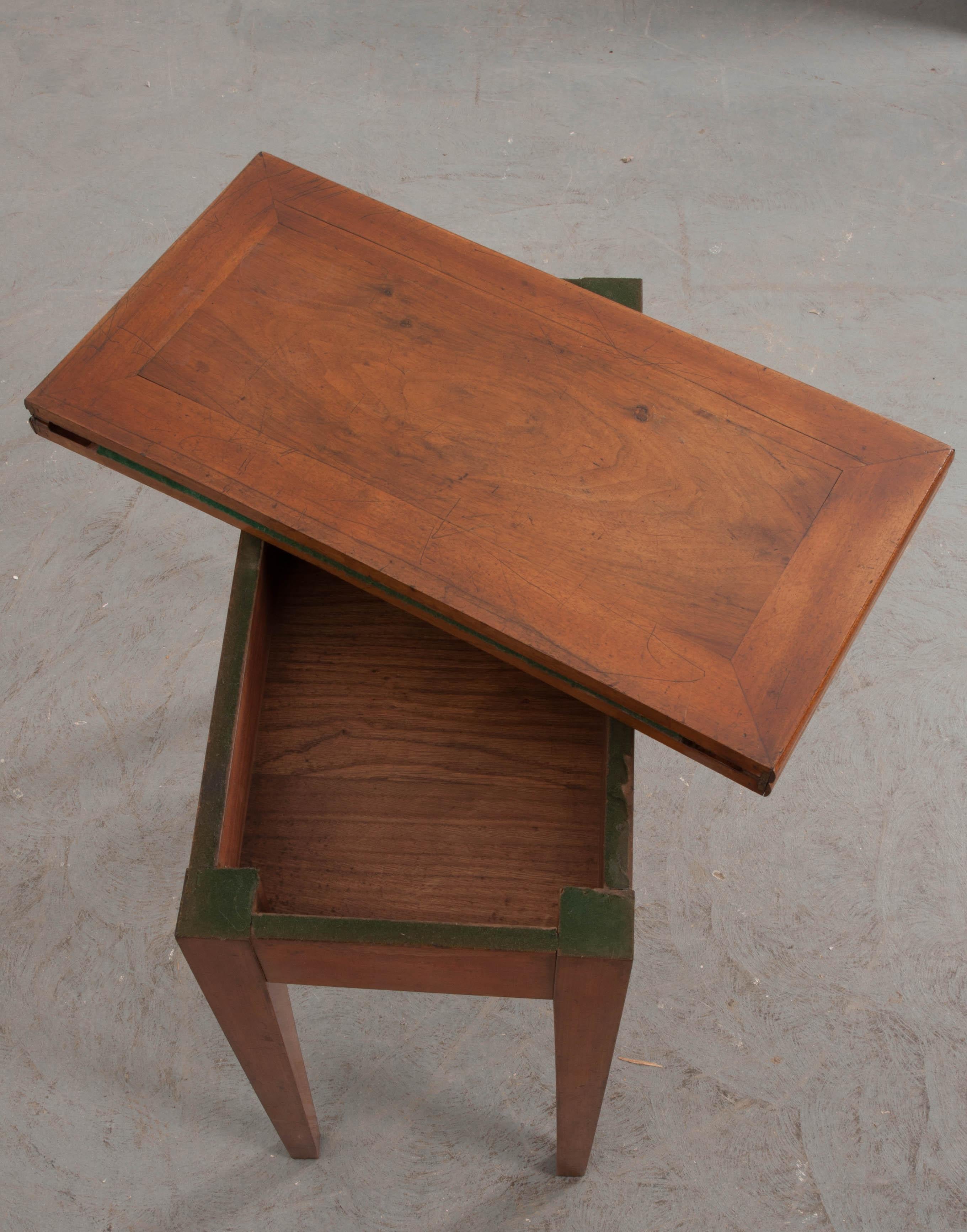 This charming walnut fold-over games table, circa 1900, from provincial France, has simple, yet stylish, surface inlay, a warm mellow patina, and raised on elegant tapering square legs. The top opens to reveal a circular green felt gaming surface