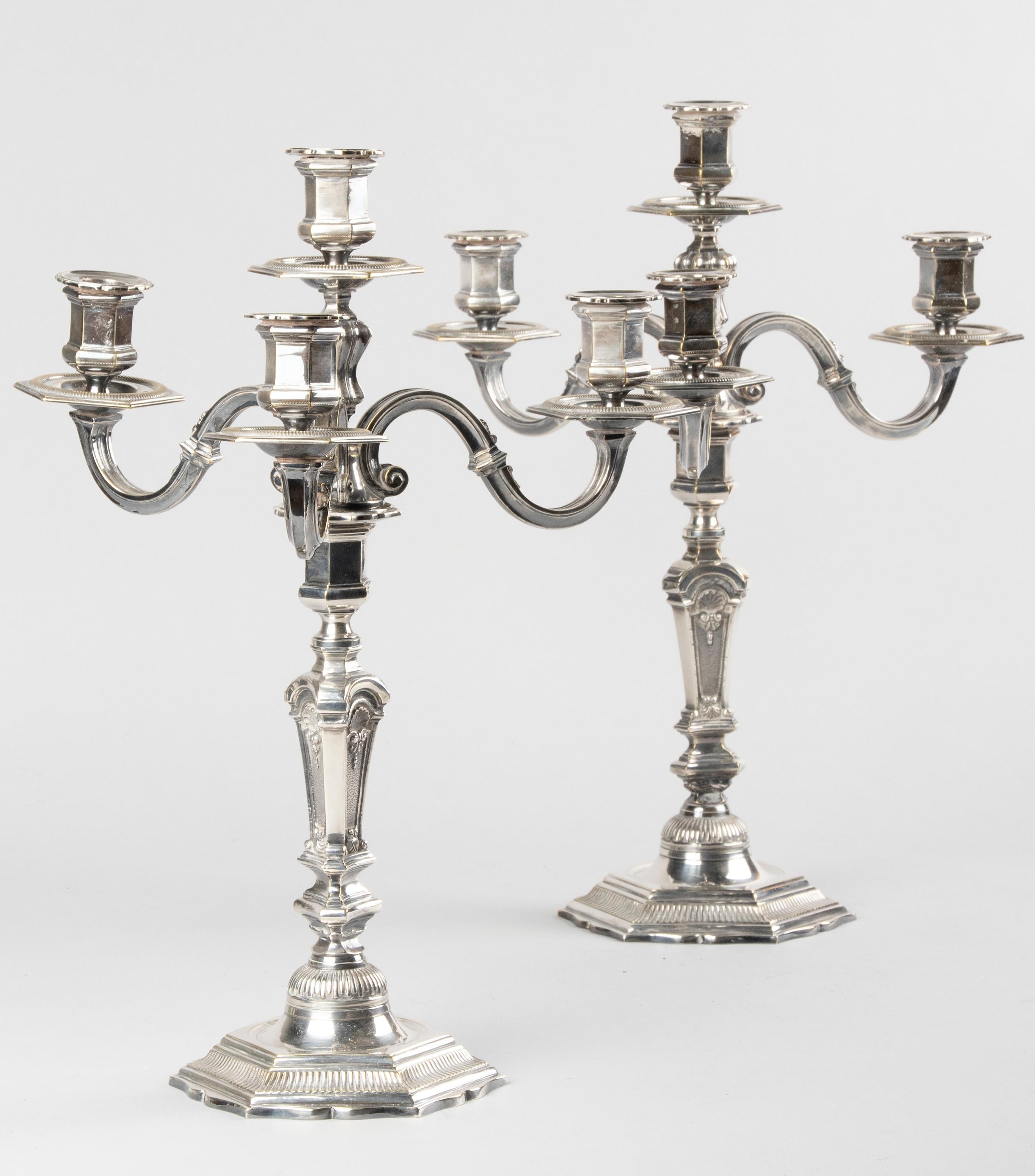 A pair of beautiful antique French Regency-style silver plated candlesticks. The candlesticks have beautiful decorations and ornaments. They are heavy and sturdy. There is room for 4 candles per candlestick. The top part is removable, so they can