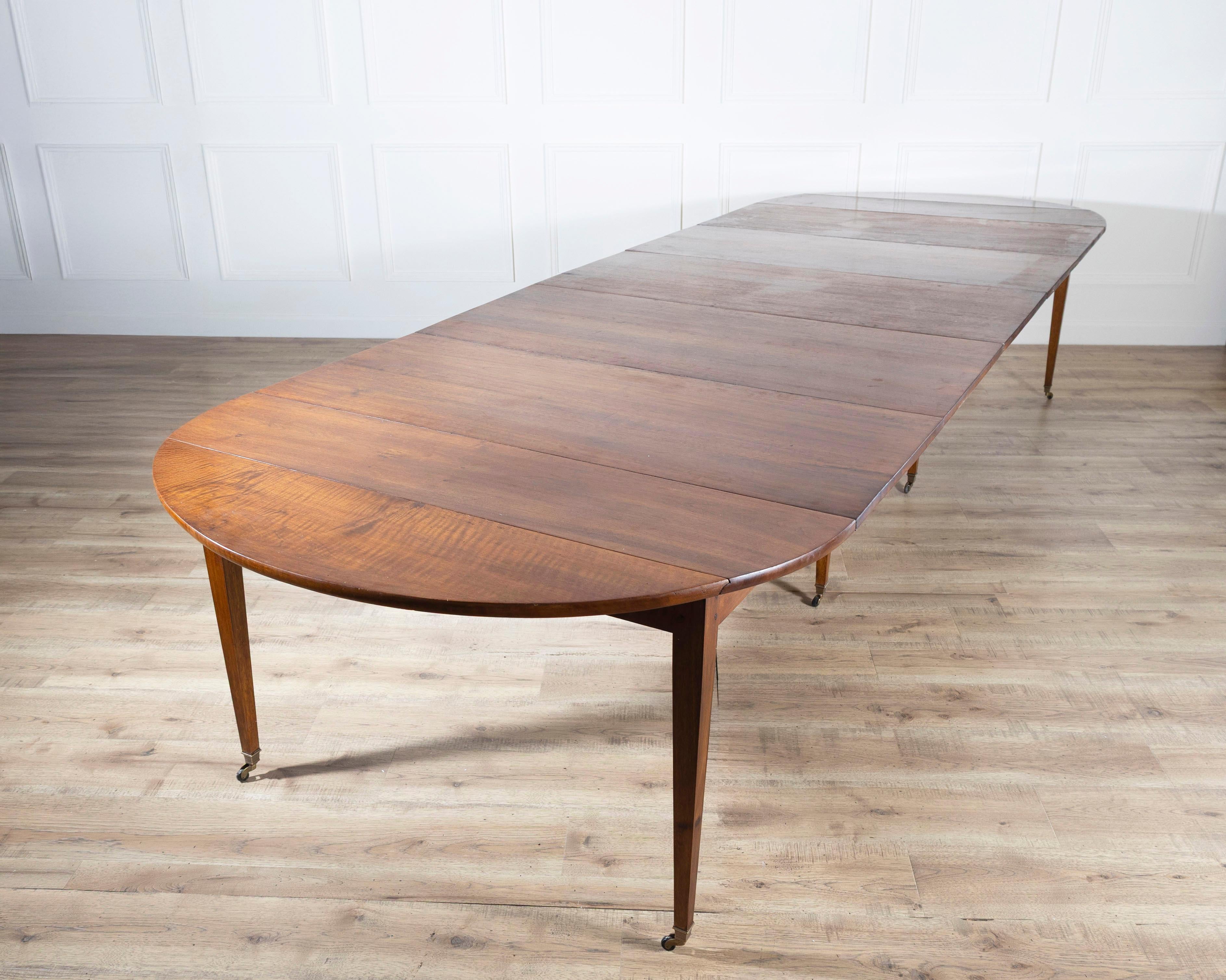 A beautifully crafted early 20th-century French extension dining table in the Restoration style, made from richly grained solid walnut. Measuring an impressive eight feet when fully extended, this elegant piece offers both grandeur and versatility —