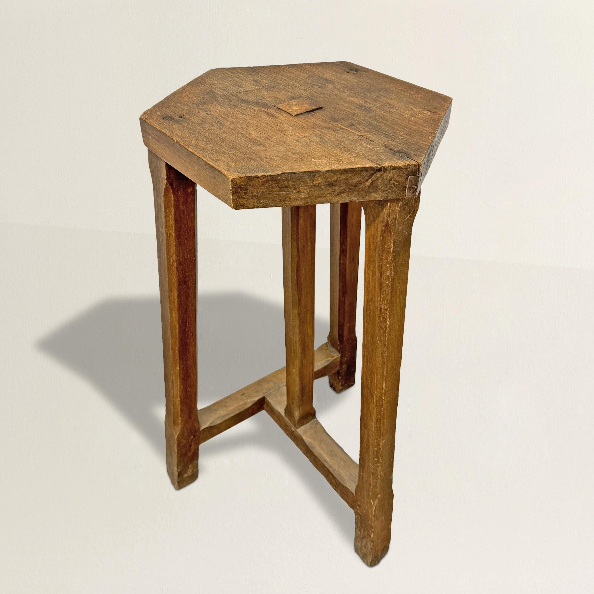 This early 20th-century French artist's sculptor's stand, crafted from oak, is a versatile and elegant piece for displaying your favorite artwork, plant, or beverage. Its hexagonal top is set over an asymmetrical base with three square, chamfered