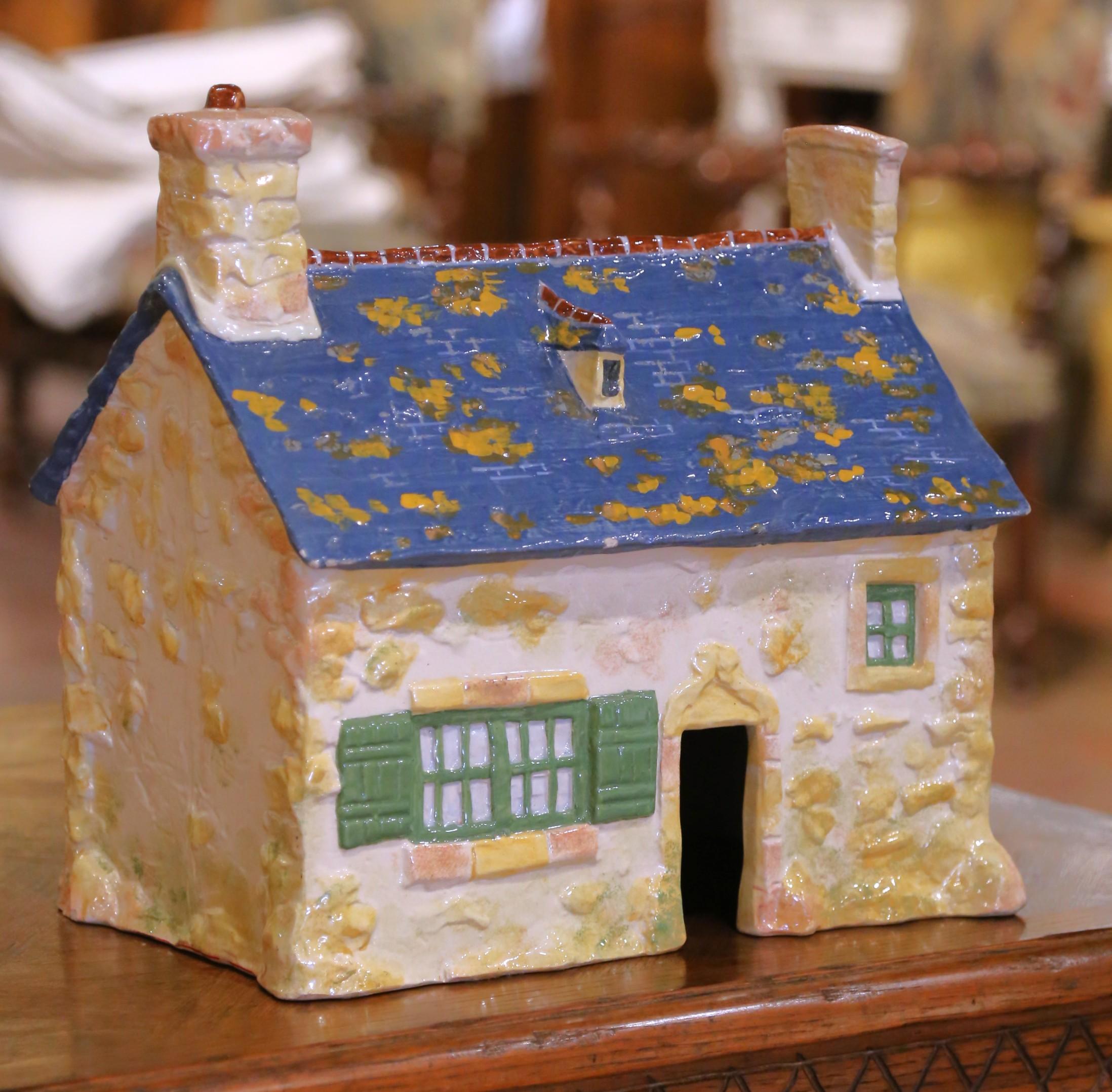 Decora una mensola, una consolle o un mobile da cucina con questa incantevole casa scultorea in maiolica, realizzata in Bretagna dall'Atelier Henriot Quimper e firmata dal noto artista bretone J.E. Sevellec. Realizzata intorno al 1920, la struttura