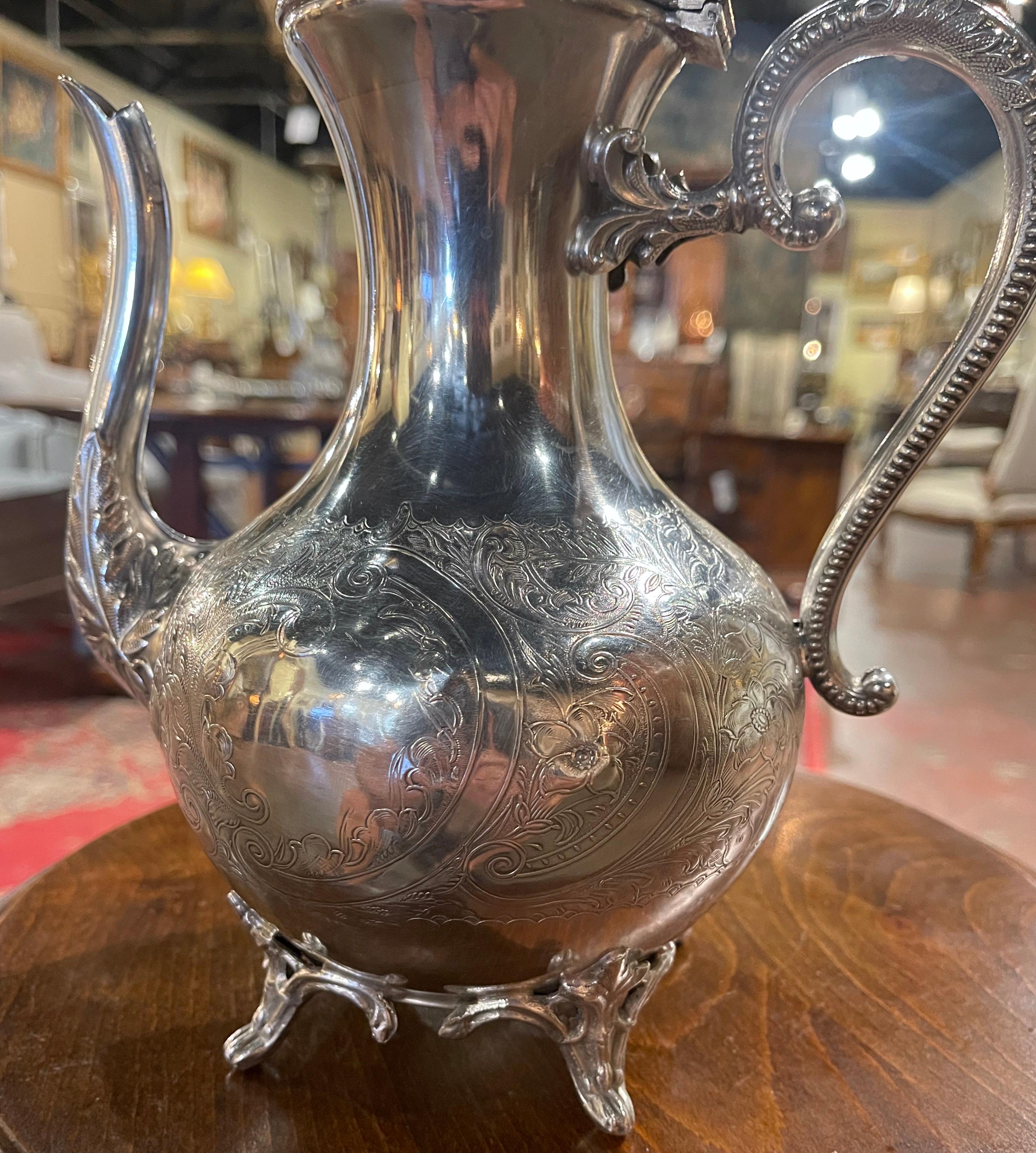 Crafted in France circa 1920 the teapot stands on four beautiful curved feet and features intricate leaf and flower motifs and a gleaming silver finish all throughout. The lid is decorated with a elegant flower finial for opening and closing the