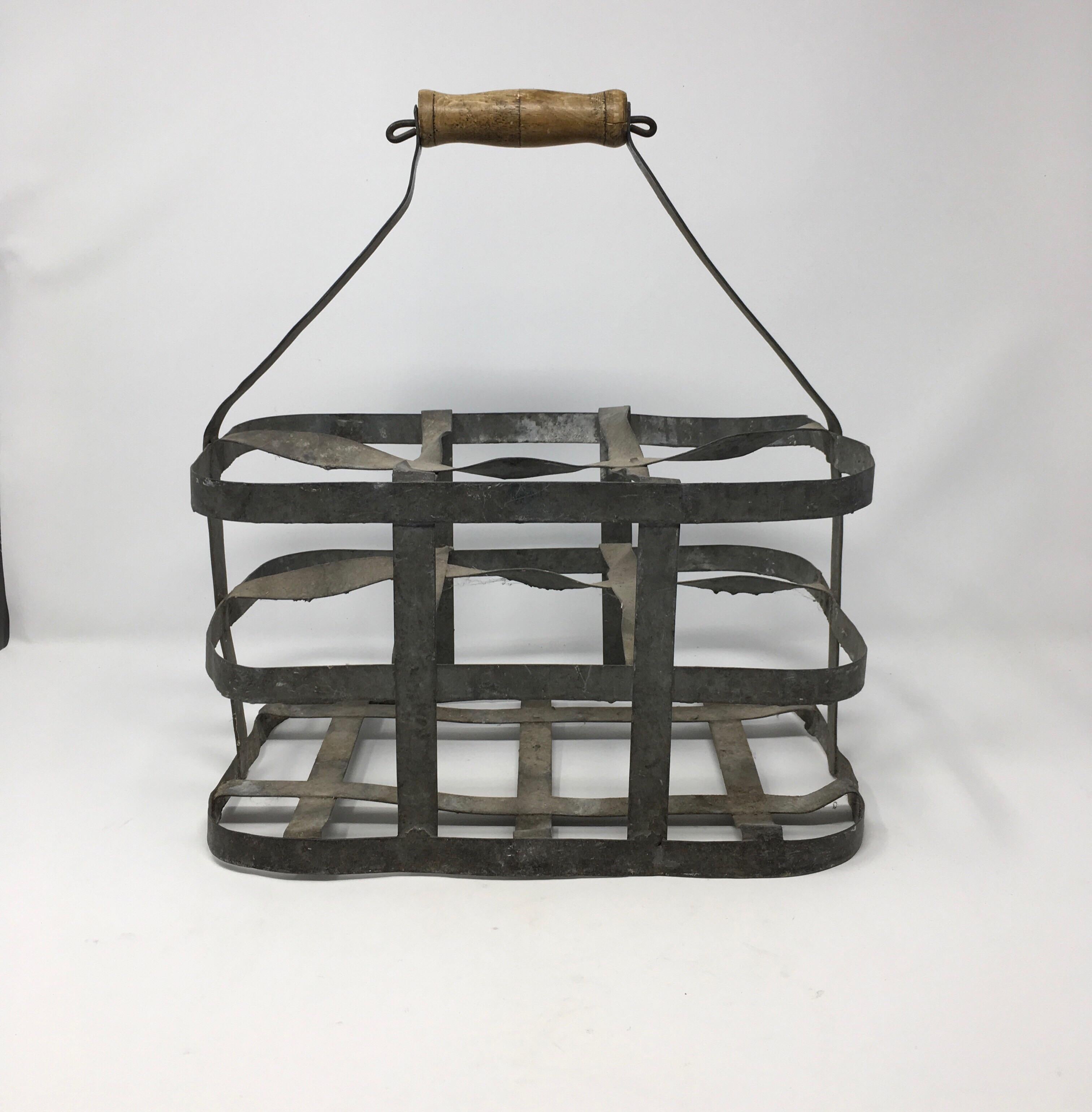 Early 20th century French six bottle wine carrier basket from France. Antique French handmade wine bottle carrier rack for 6 bottles, made of metal with a wooden handle. Used in France for carrying wine bottles when going to the wine cave. Can now