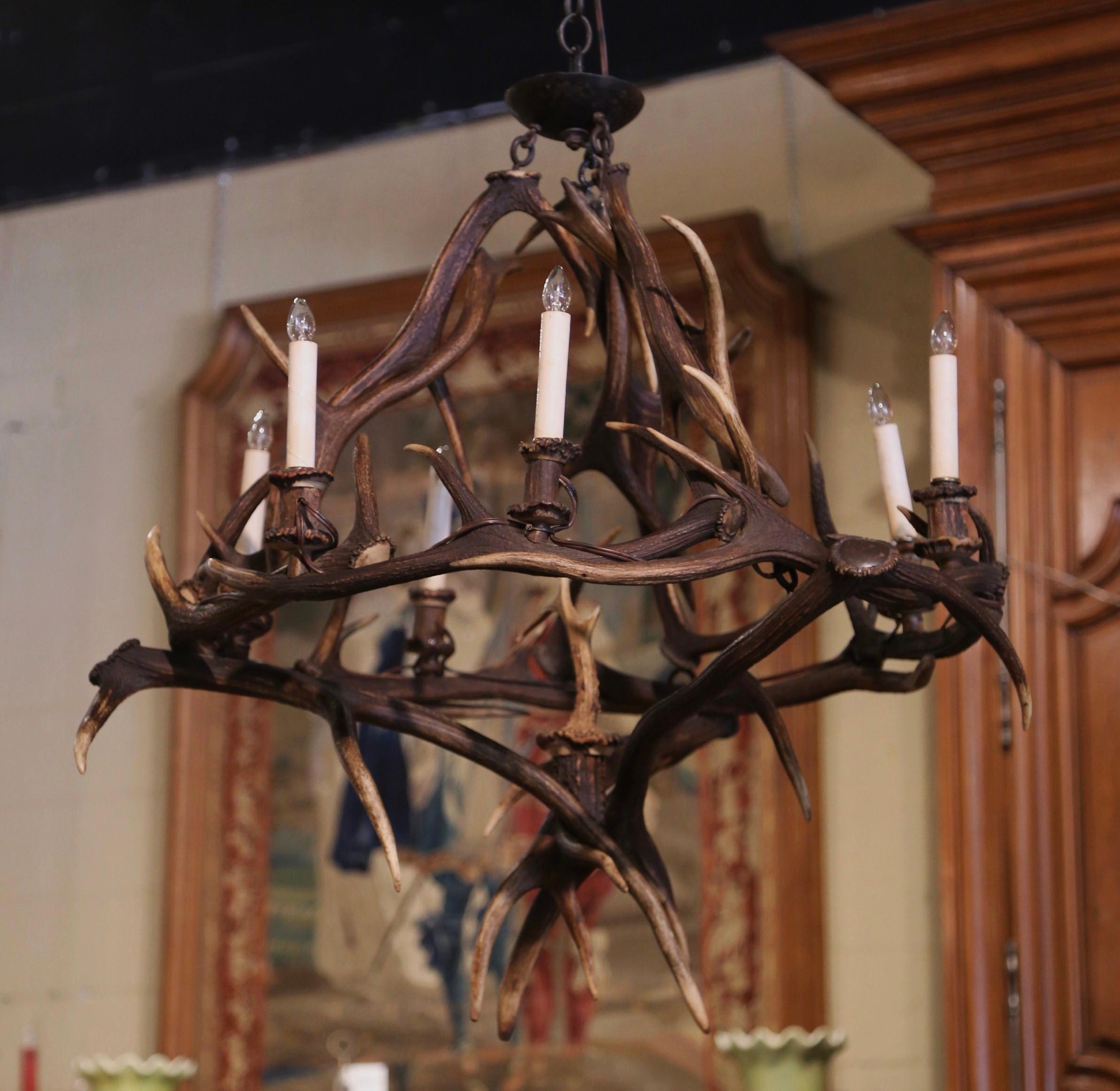 Decorate a ranch or a log cabin with this elegant antique real antler chandelier! Handcrafted in France circa 1920, the large fixture is built using a dozen natural deer horns; it has six lights newly wired and further dressed with horn candle