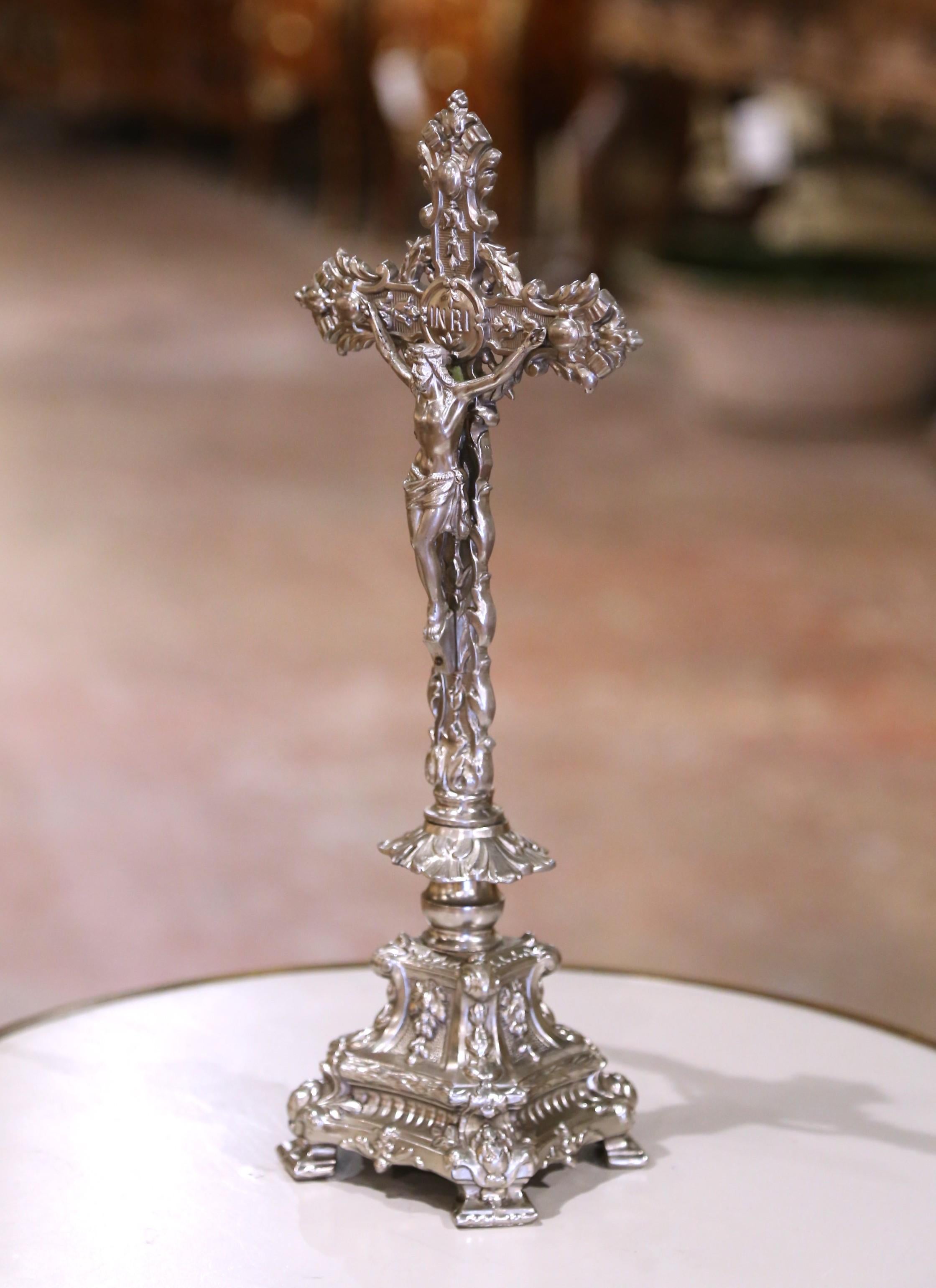 Añade un sentido de reverencia y grandeza a cualquier espacio sagrado o decorativo con este crucifijo de altar de gran detalle.  Realizada en Francia hacia 1920, esta pieza de metal plateado presenta una expresiva figura de Cristo sobre una cruz de