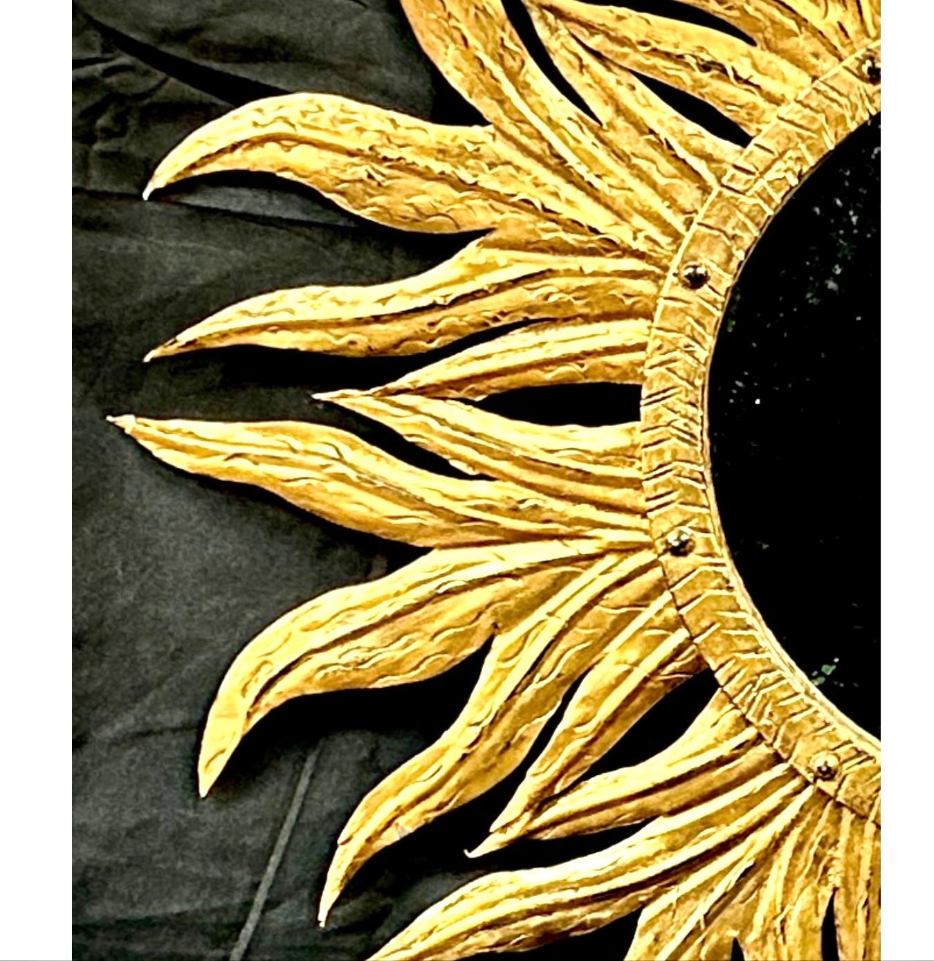 Lovely mid- 20th century French Starburst Sunburst wall mirror featuring gold leaf paint on a metal frame.  Mirror has gold rays that extend out in alternating lengths. Features vintage mirror glass in the center. Mirror can be used as part of a