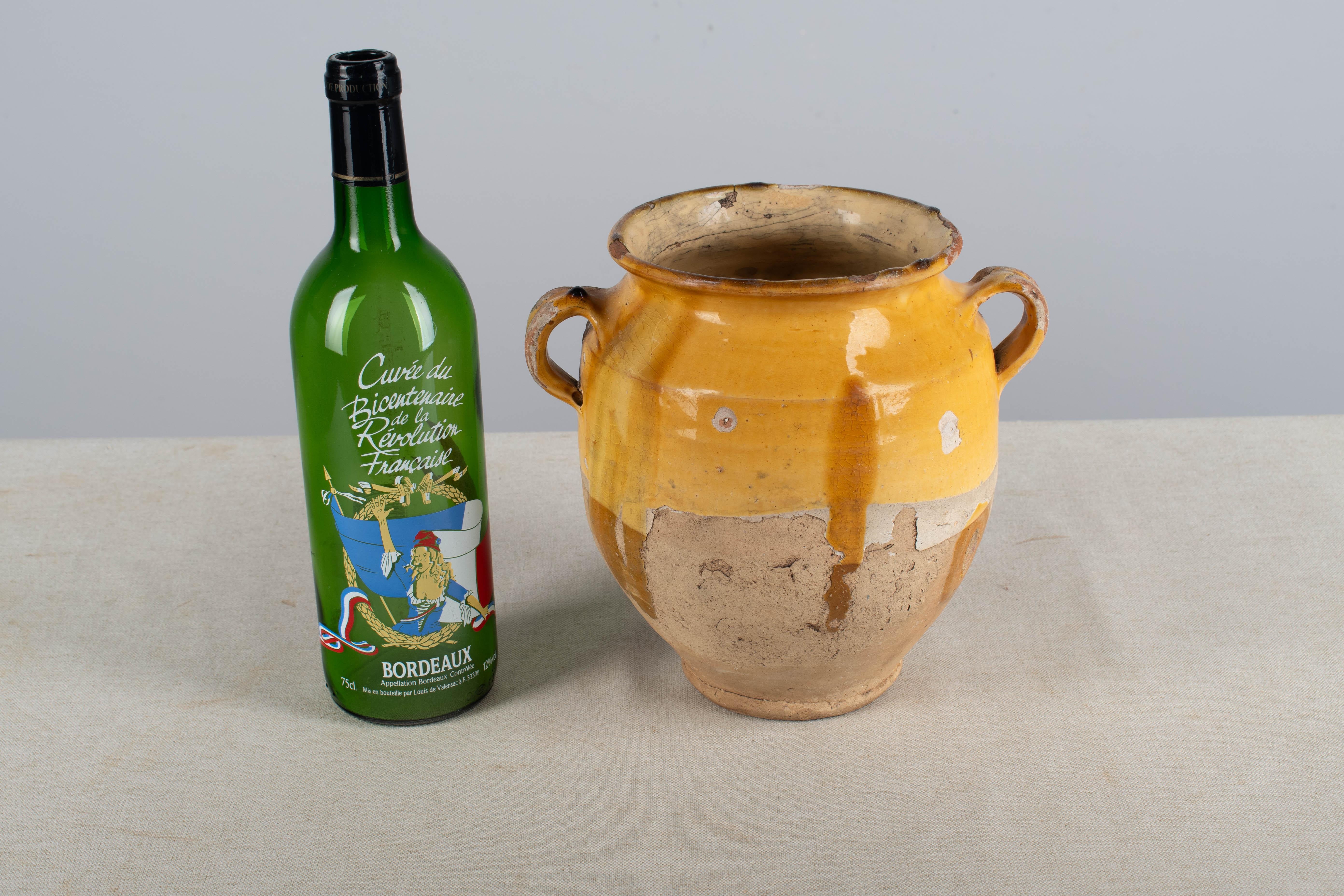 An earthenware pottery from the Southwest of France with traditional yellow, ochre glaze. Some chips and losses to glaze. These ordinary earthenware vessels were once used daily in the French country home and have beautiful rustic glazes of green,