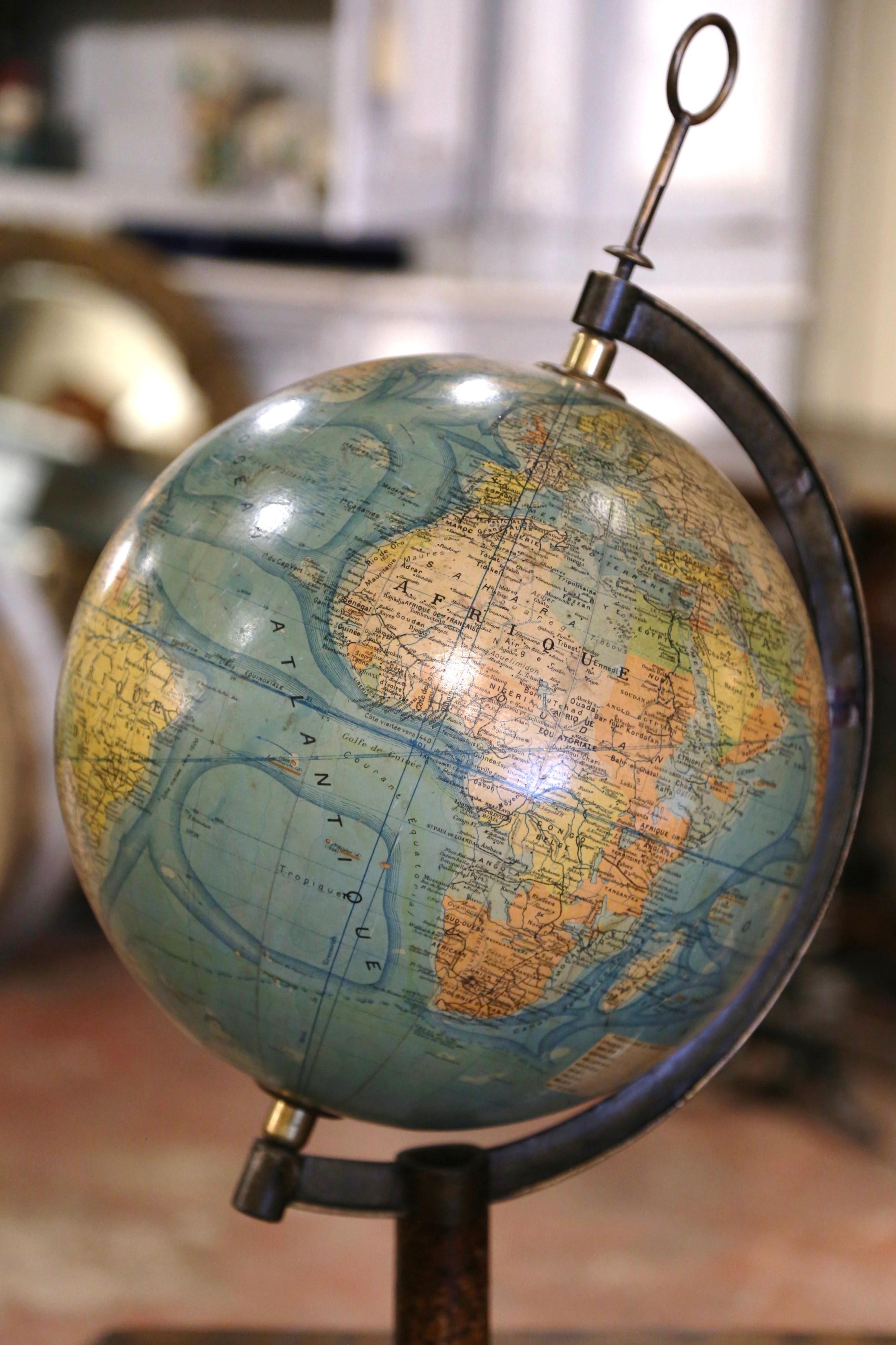 Décorez un bureau avec ce globe terrestre antique magnifiquement conservé. Fabriquée en France vers 1930, cette pièce terrestre est montée sur un socle tripode en fonte peint en doré et décoré de coquillages et de motifs floraux. La tige en laiton