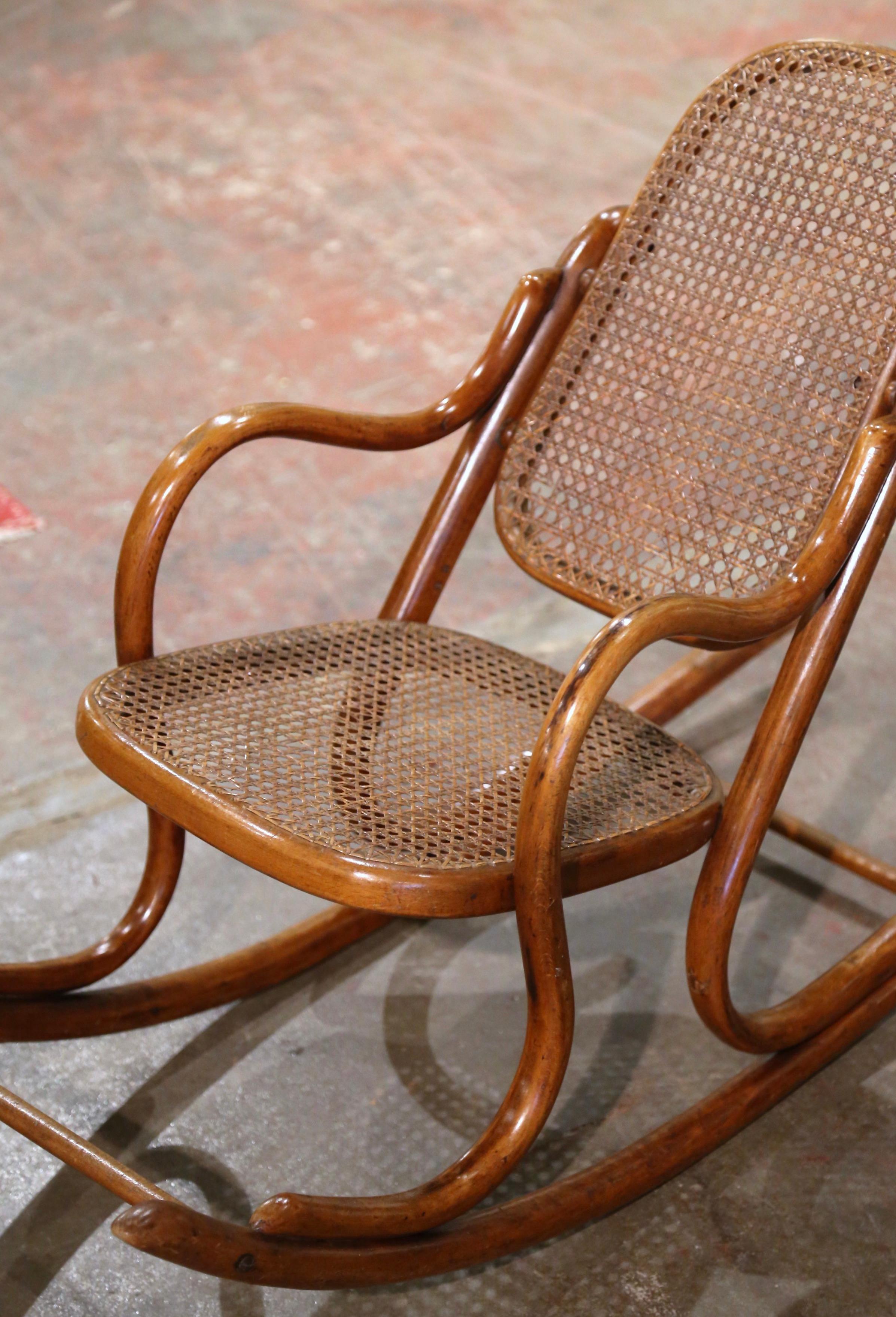 Décorez une chambre d'enfant avec ce fauteuil à bascule Art déco antique pour enfant. Fabriquée en France vers 1920 dans l'affaire de l'ébéniste germano-autrichien Michael Thonet (1796-1871), et construite en bois courbé, la chaise repose sur des
