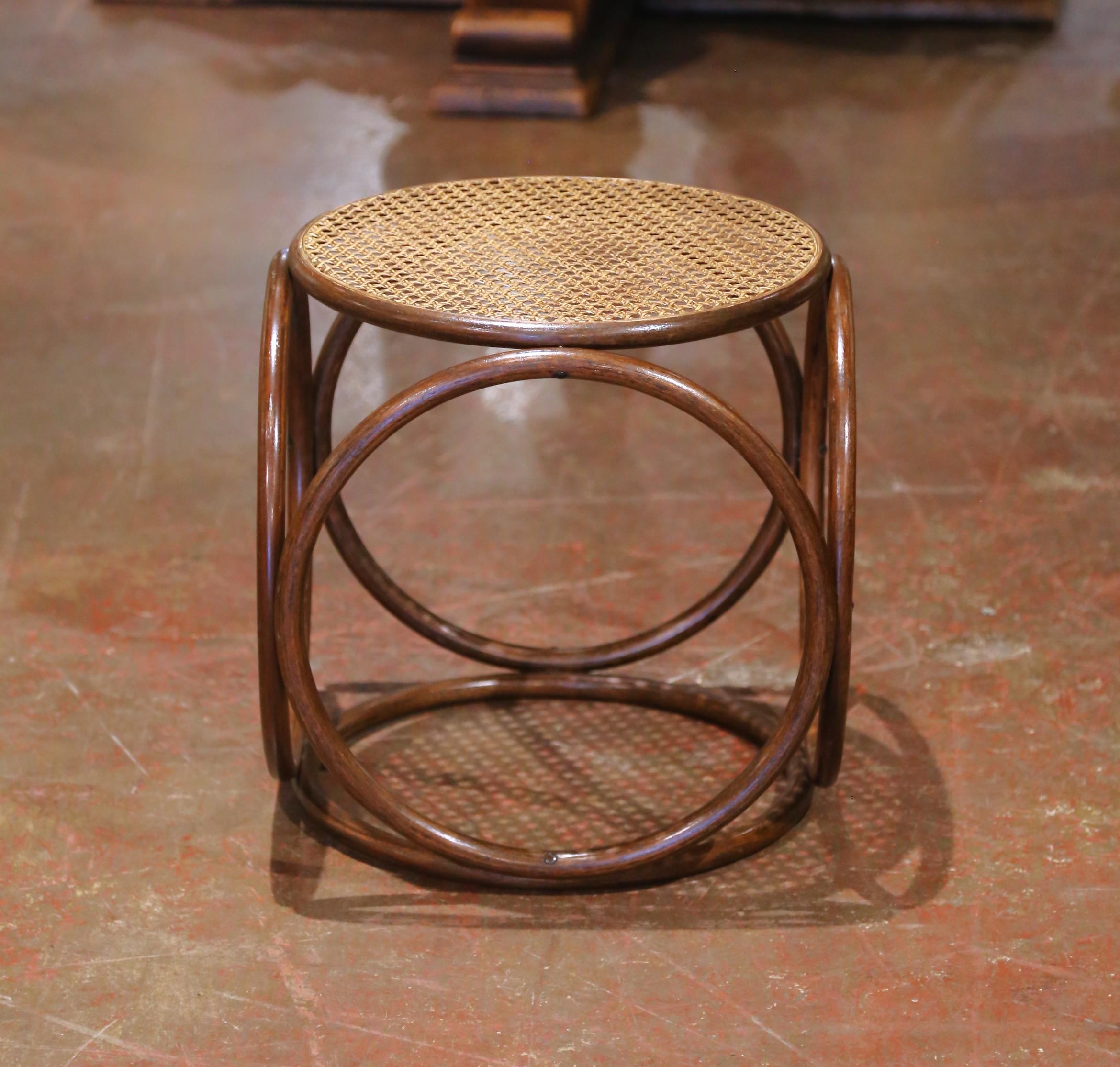Fabricado en Francia hacia 1930 y atribuido al célebre diseñador austriaco-alemán Michael Thonet, este elegante taburete muestra el atractivo intemporal de los muebles de madera curvada. El asiento circular está tejido a mano con caña tradicional,