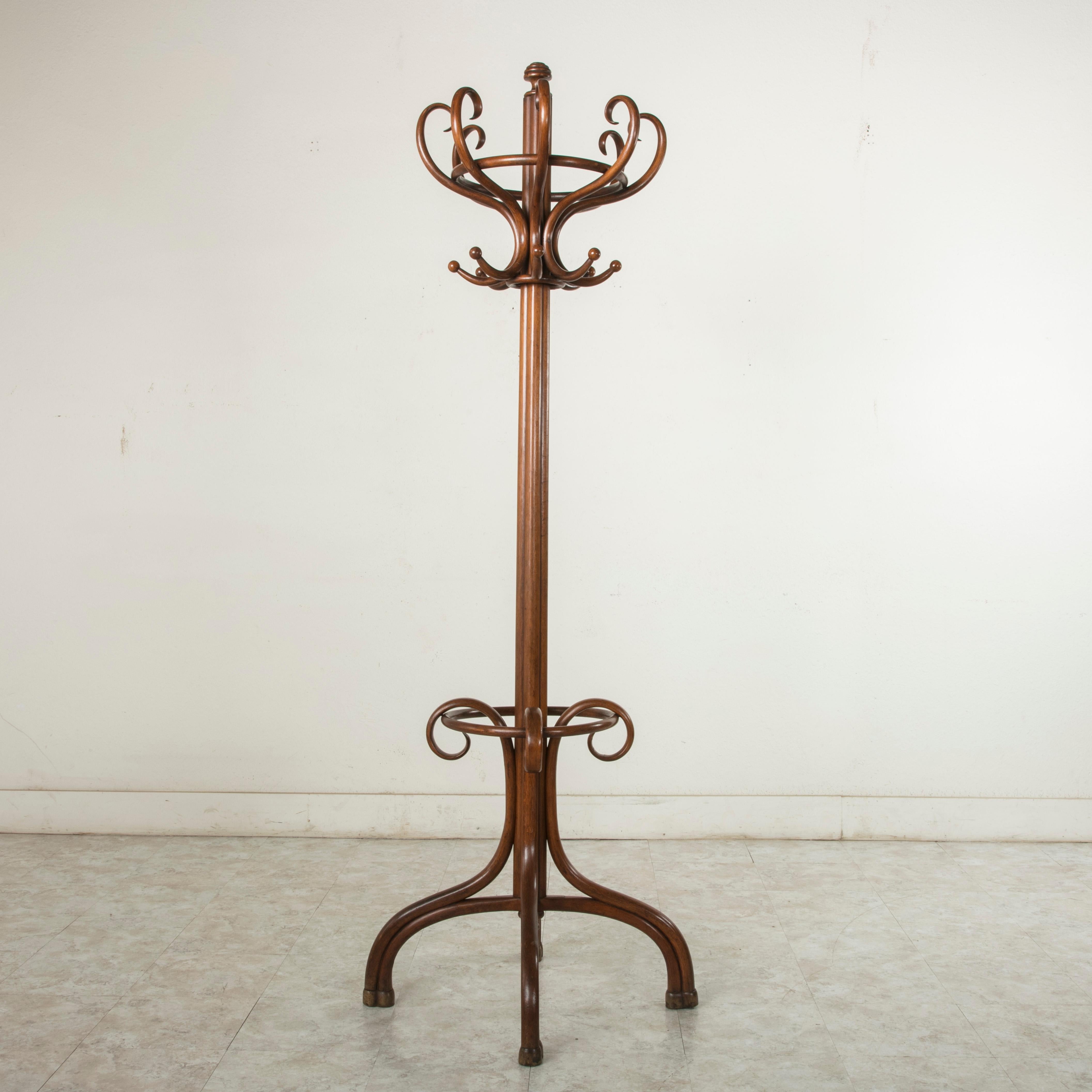 This Classic Thonet style hat and coat rack or hall tree is made of richly finished bent beech wood. It features sixteen hat and coat hooks and an umbrella holder below. A maker's plaque under the umbrella holder is marked Morel Goyer, Lille. A