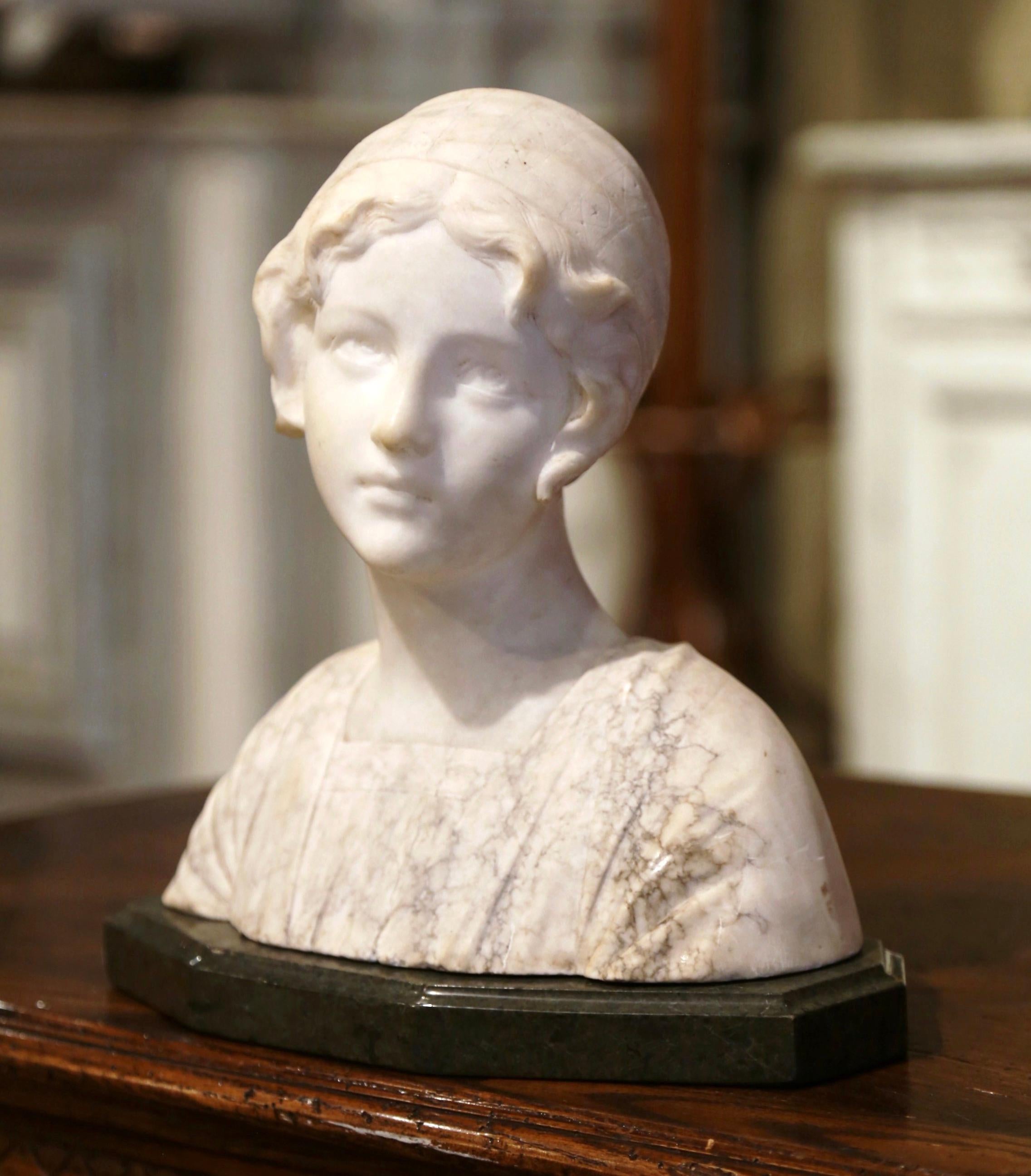 Decorate a shelf or desk with this antique two-tone and variegated marble bust. Created in France circa 1930 and rising on a separate flat green base, the sculpture features a young woman looking to the side, dressed in pre-20th century clothing and