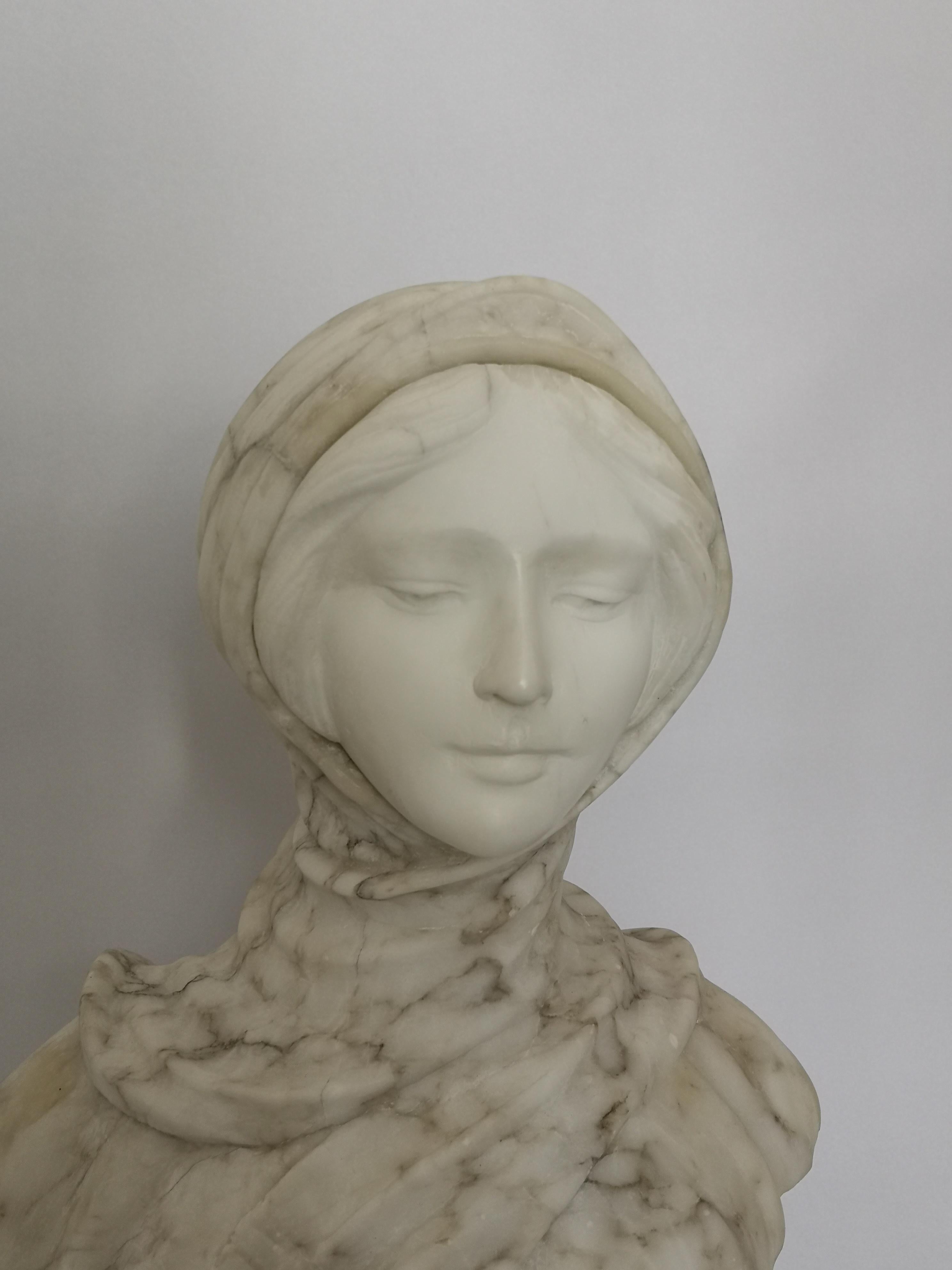 A French marble bust of a girl, her hair wrapped in a headscarf and her eyes looking downwards. Her scarf in white/grey veined marble with a white marble face.
Indistinctly signed.
French, circa 1900.