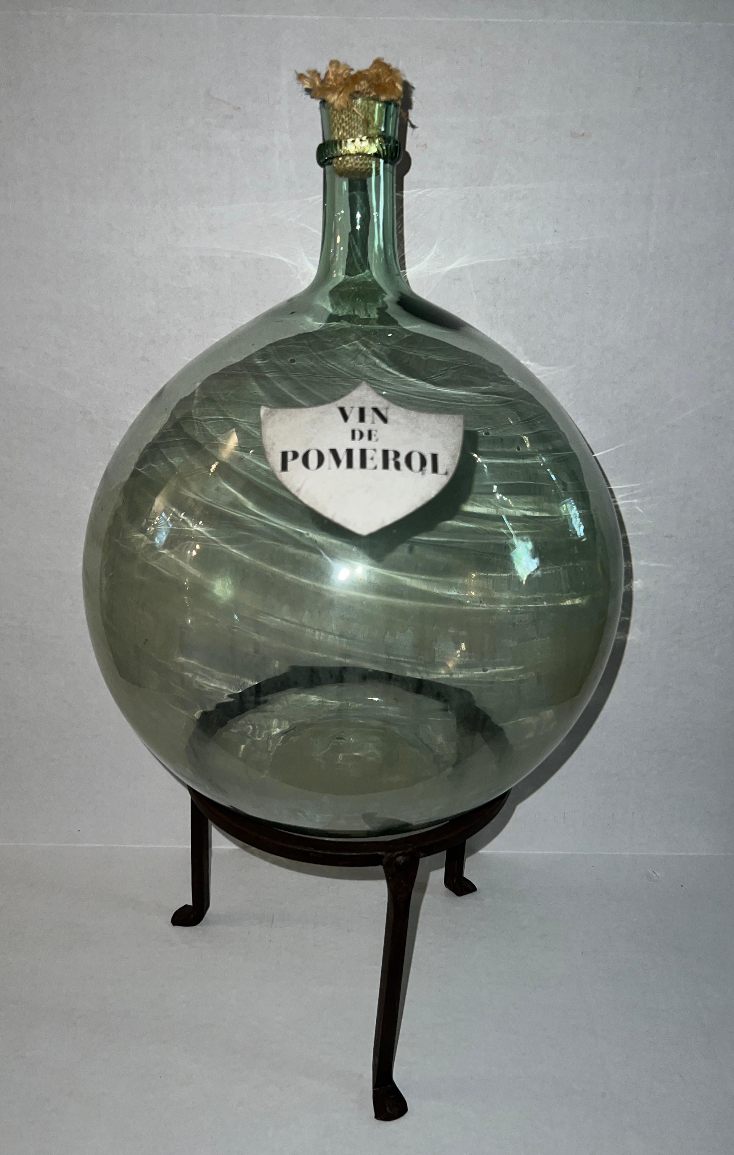 The French Vin De Pomerol Glass Blown Demijohn, standing at 15 inches, is a stunning artisanal masterpiece for wine enthusiasts.

The wrought iron stand is included 