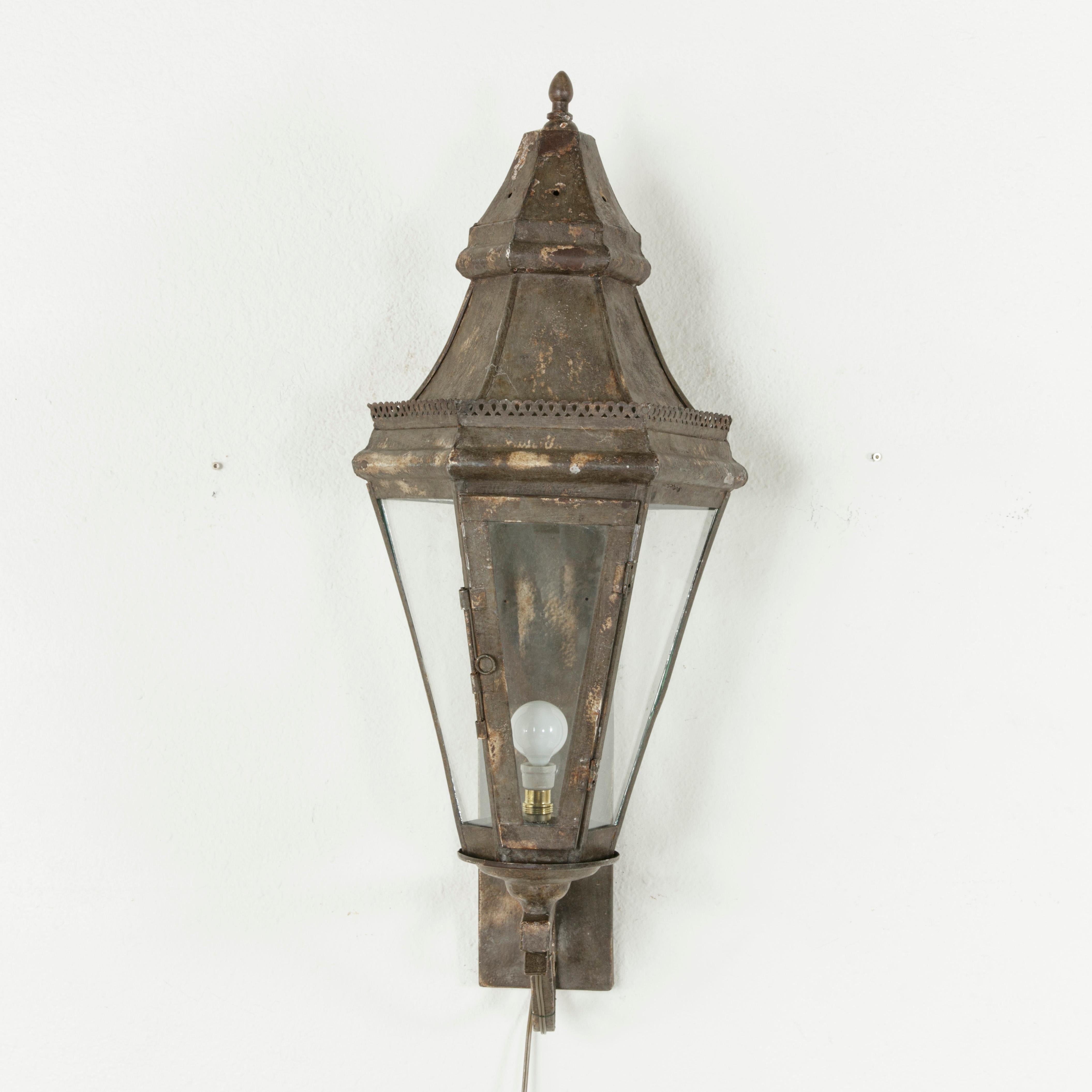 These very large French wall mounted Venetian lanterns stand at an impressive 34 inches in height. Their faceted dome tops are finished with a pierced gallery and finial and rest on a hexagonal base with glass on all sides. The front pane opens to