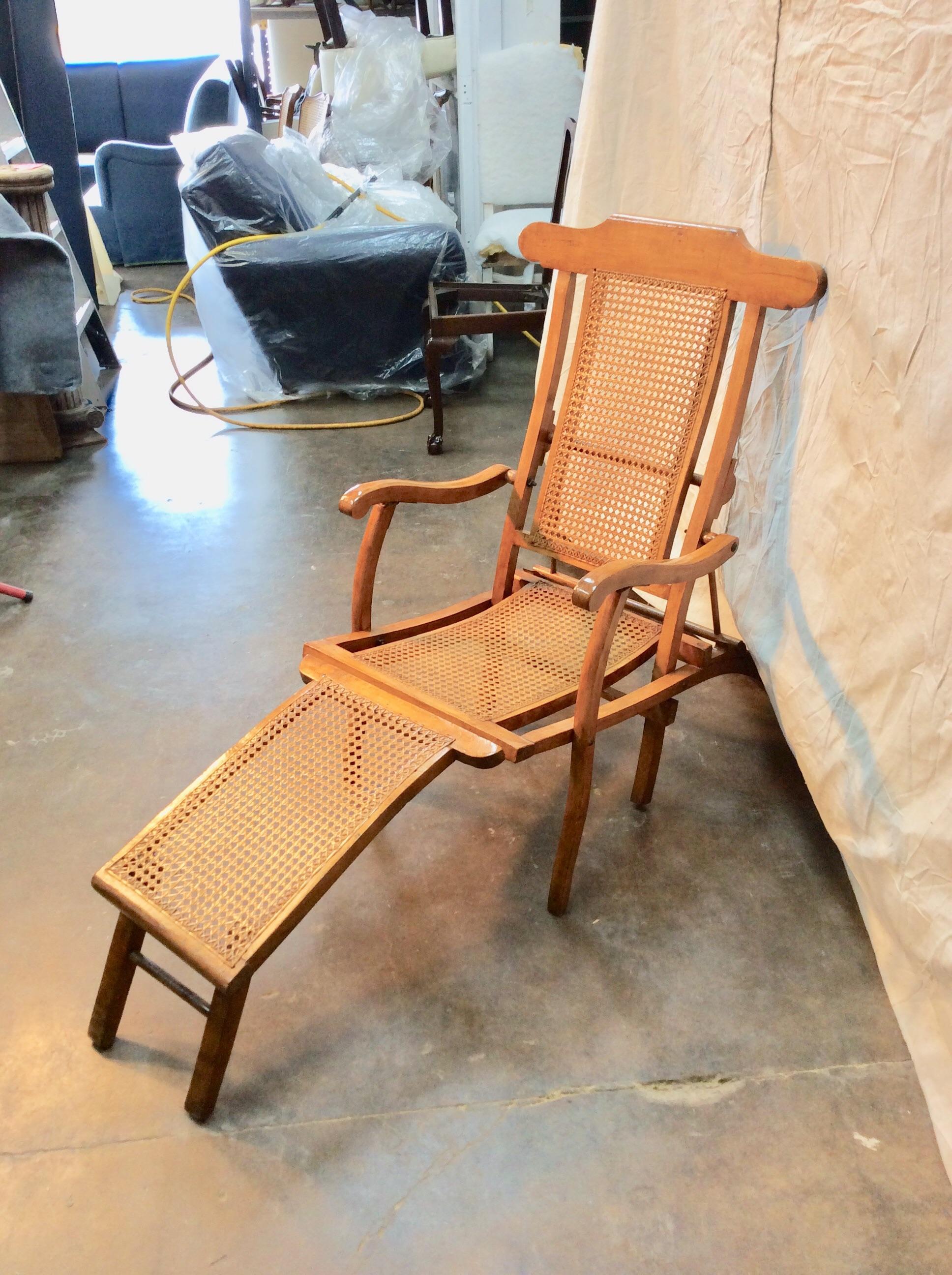 Found in the South of France, this stylish Early 1900s French Walnut and Cane Deck Chair was once used on steamer ships across Europe. The piece features a walnut frame with cane back and seat flanked by scrolling arms and splayed legs. Designed