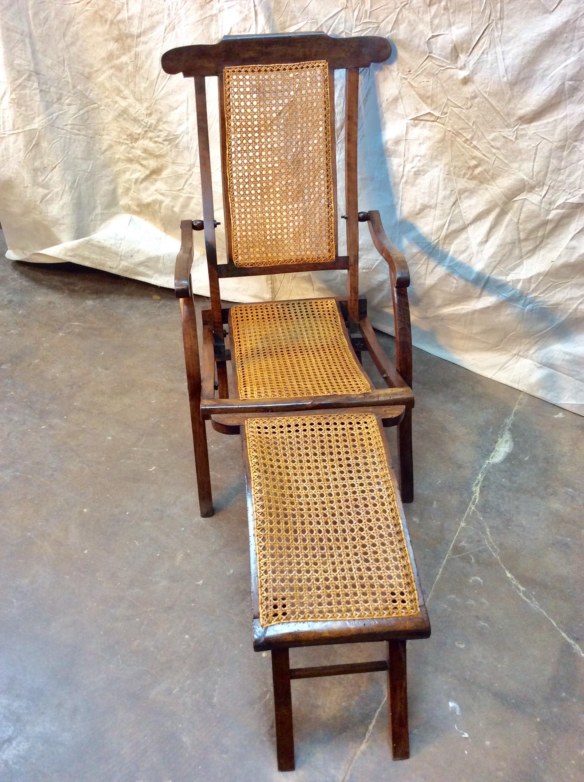 Found in the South of France, this stylish Early 1900s French Walnut and Cane Deck Chair was once used on steamer ships across Europe. The piece features a walnut frame with cane back and seat flanked by scrolling arms and splayed legs. Designed