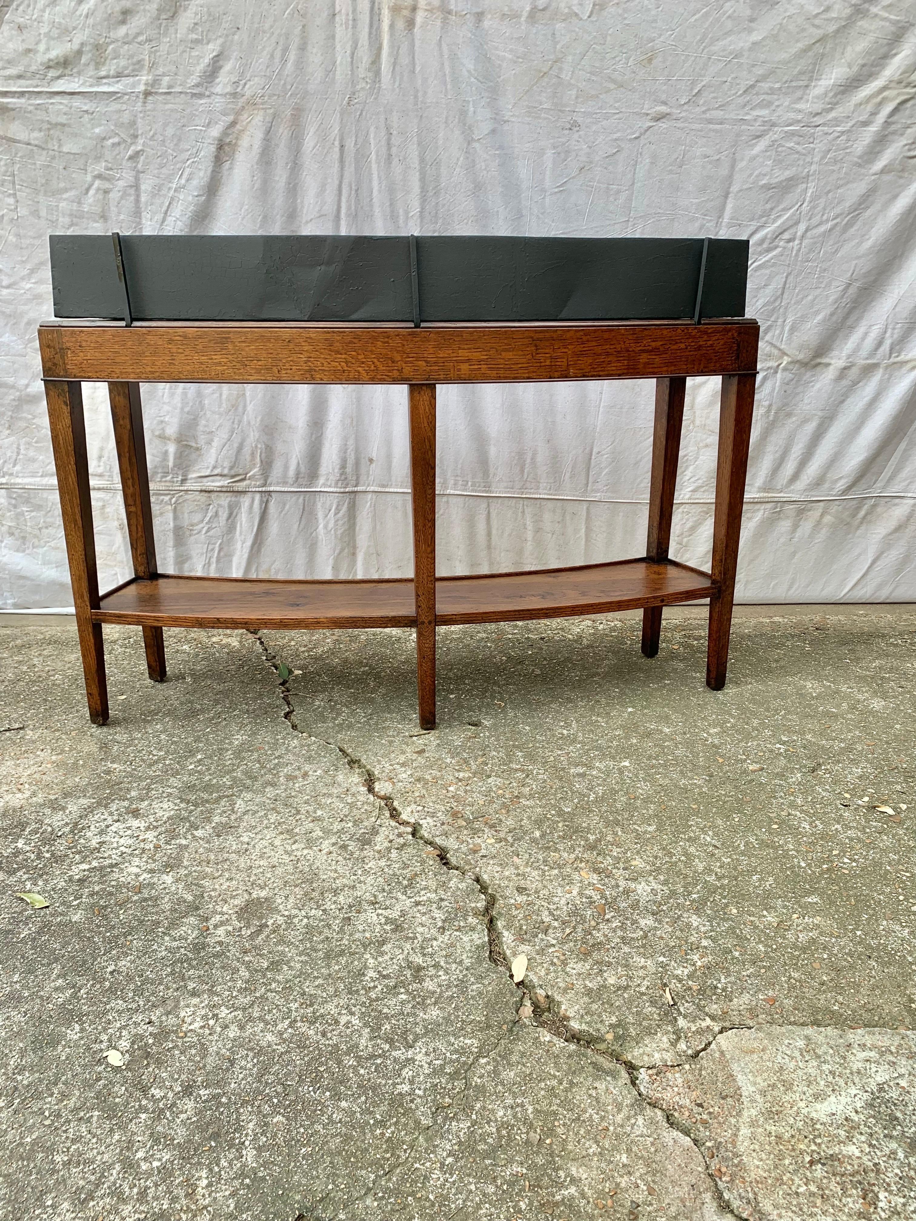 Trovato nel sud della Francia, questo portapiante o jardiniere del XX secolo è stato realizzato da artigiani francesi in legno di noce nei primi anni del 1900. Costruita in modo unico, la base della fioriera presenta un fronte e un retro a forma di