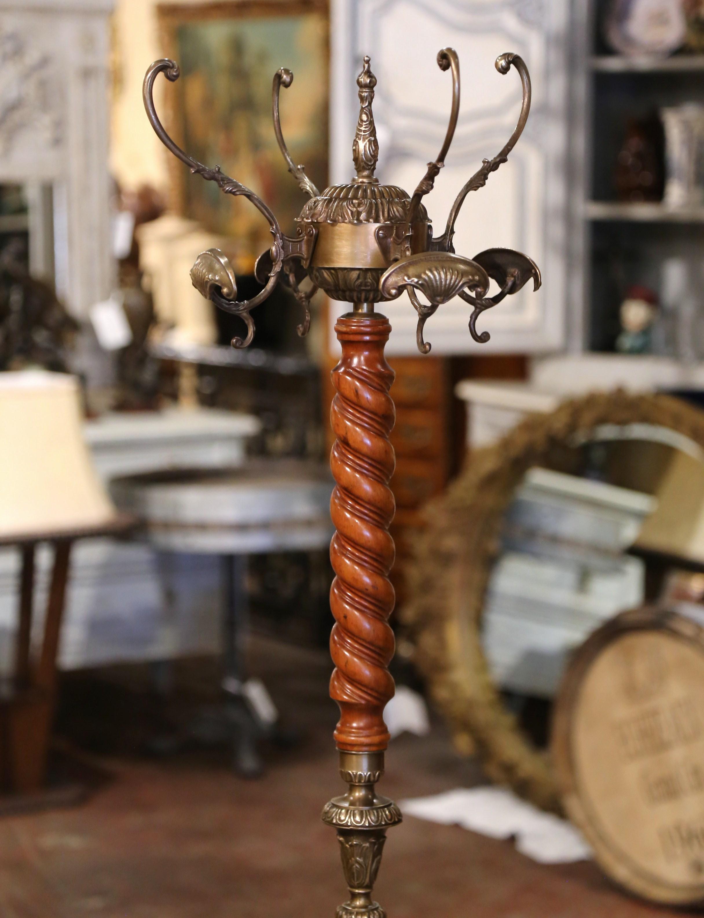This antique carved fruit wood and brass hall tree was crafted in France, circa 1920. Standing on a wide female caryatid tripod form supports ending in paw feet, the tall rack features a barley twist spiral central stem decorated with brass foliate