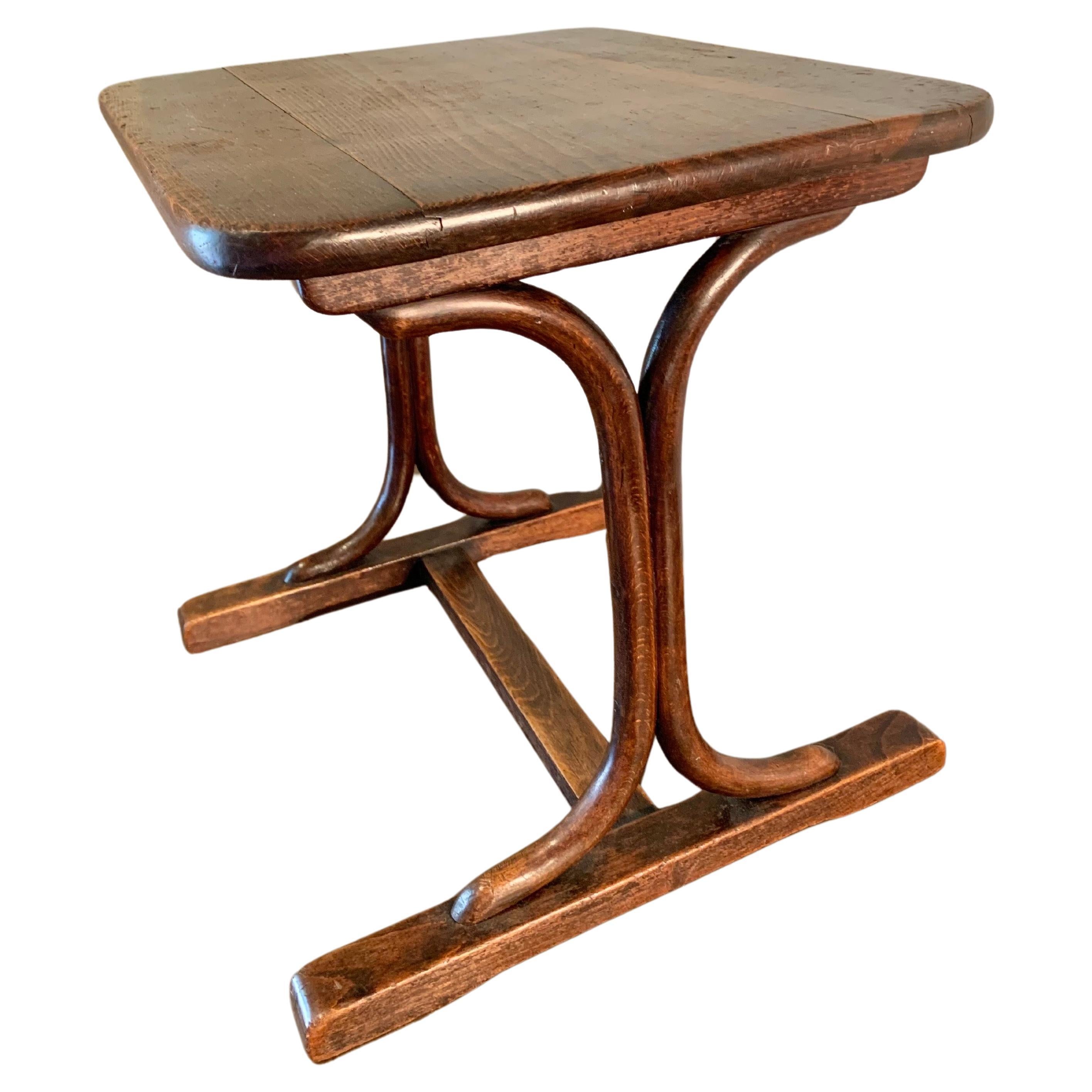 Found in the South of France, this Early 20th Century French Bentwood Trestle Side Table was crafted from walnut in the early 1900's. The side table features a rectangular top with rounded corners that is supported on two shaped bentwood trestles