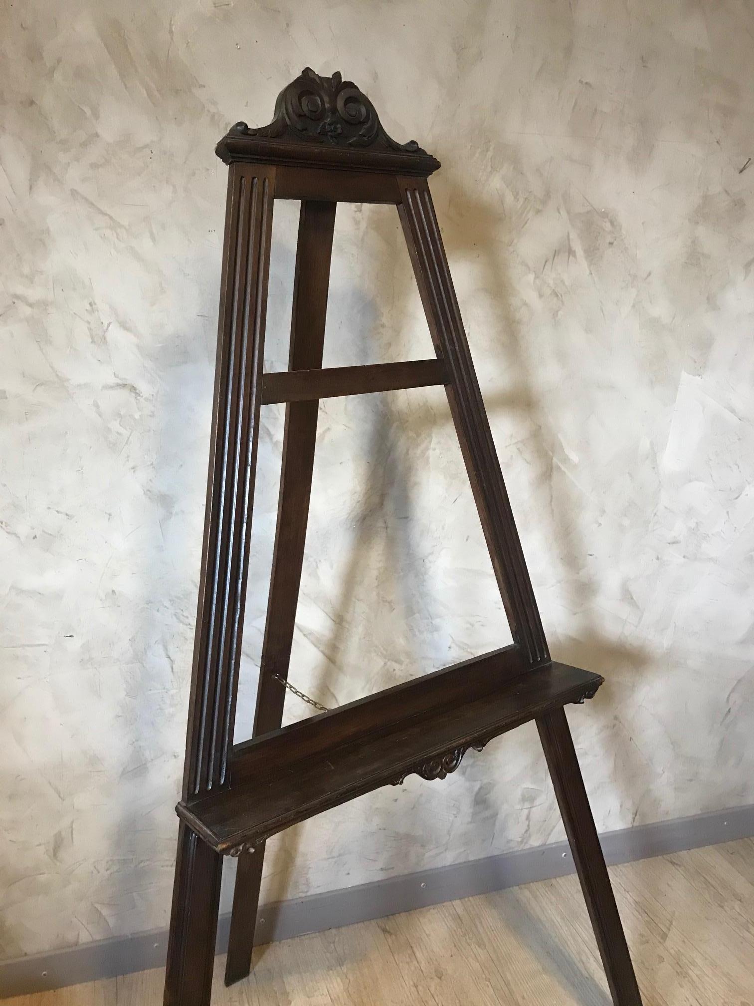 Very nice early 20th century French walnut easel from the 1900s. 
Can be closed to save space and there is a brass chain to keep the easel open. 
The shell at the top has been broken. 
Good quality. 
Can hold a large painting.