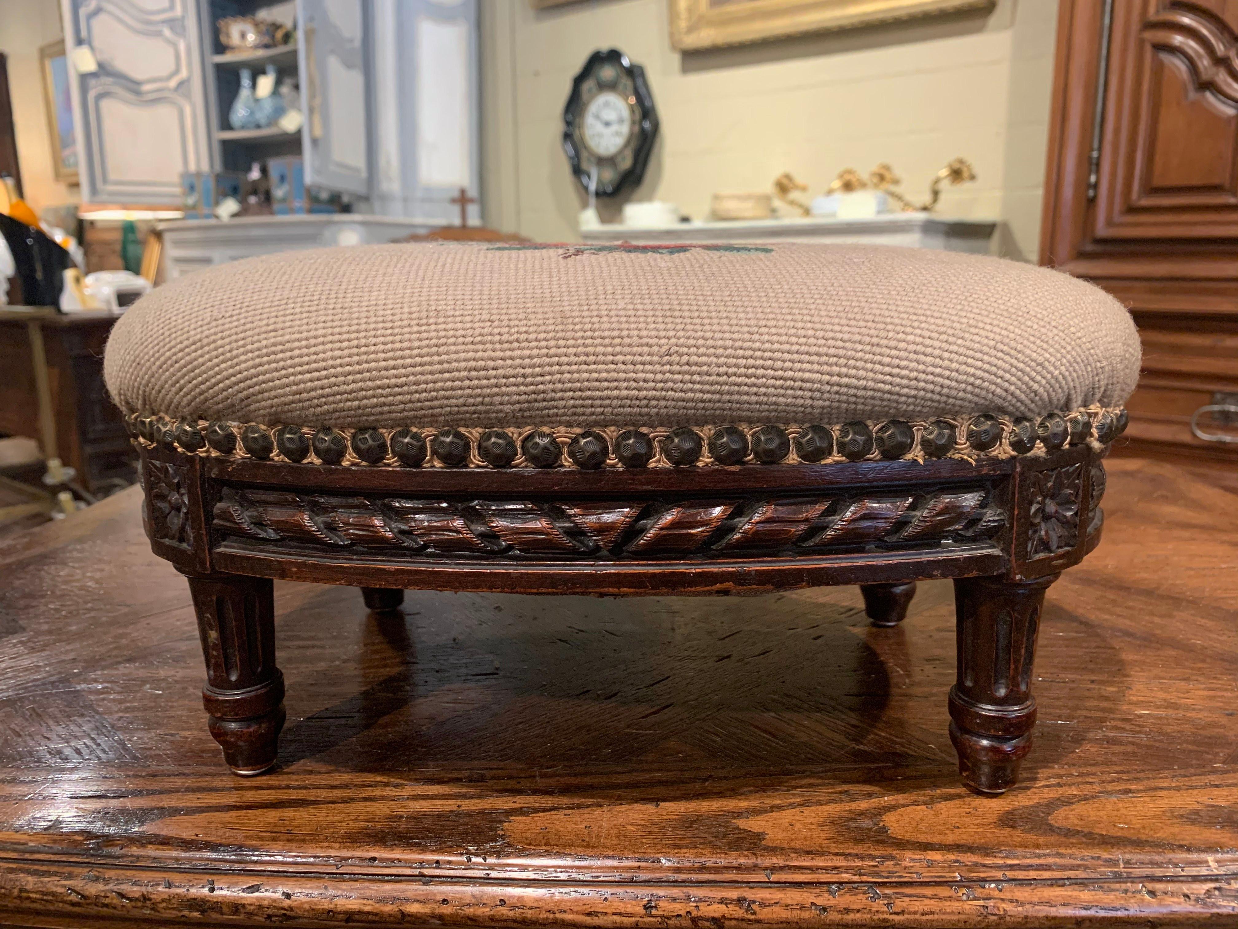 Put your feet up with style and comfort with this elegant Louis XVI foot stool. Crafted in France circa 1920 and oval in shape, the antique stool stands on tapered legs over a carved apron decorated with rosette medallions in each rounded corner.