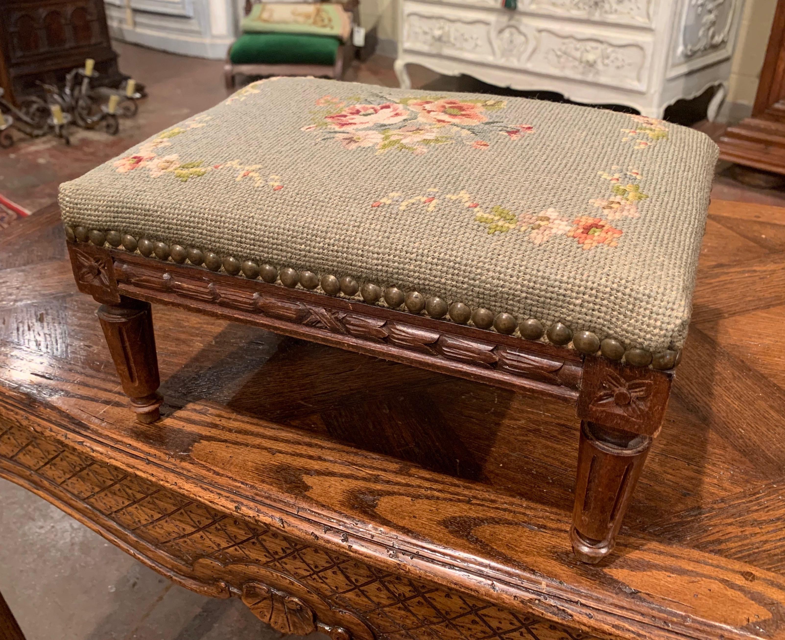 Put your feet up with style and comfort with this elegant Louis XVI foot stool. Crafted in France circa 1920 and rectangular in shape, the antique stool stands on tapered legs over a carved apron decorated with rosette medallions in each corner. The