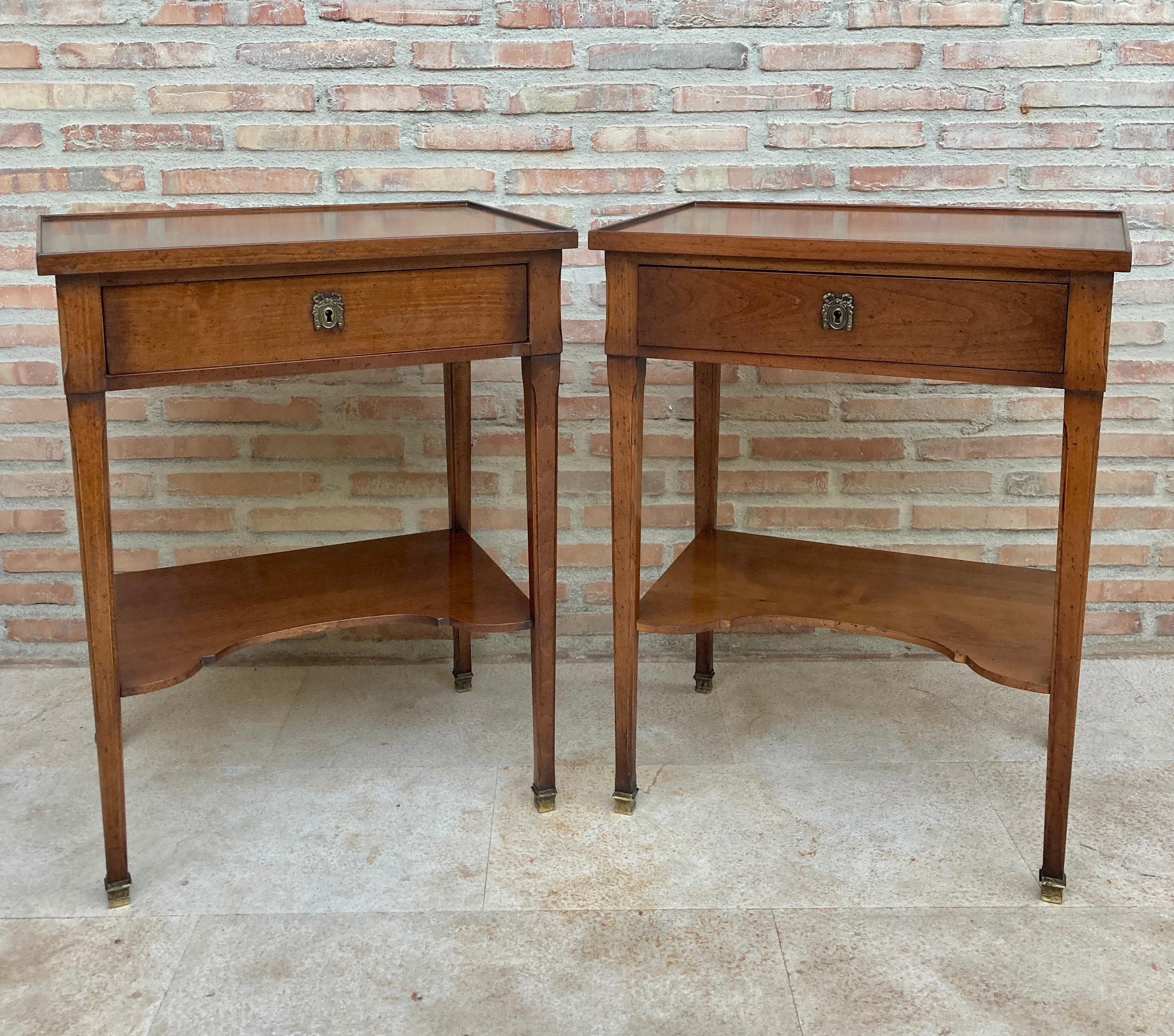 Vintage Design
Early 20th century pair of French walnut nightstands or side tables.
A pair of fine French nightstands or bedside end tables of walnut.
Each featuring a rectangular top with gallery over a shaped frieze with one drawer, set upon a