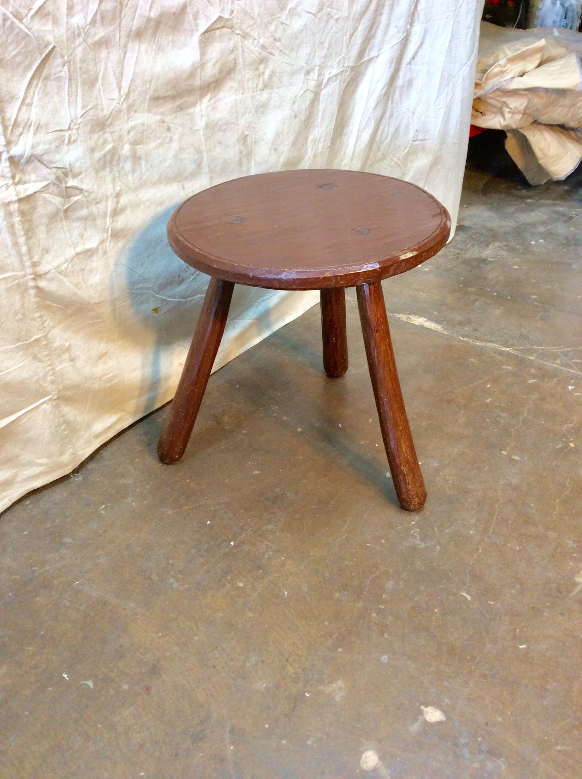 Found in the South of France, this Early 20th century French Walnut Side Table is crafted with a beveled edge round top supported by three splayed legs that widen toward the ends. The round top and sleek hand carved legs compliment the visually