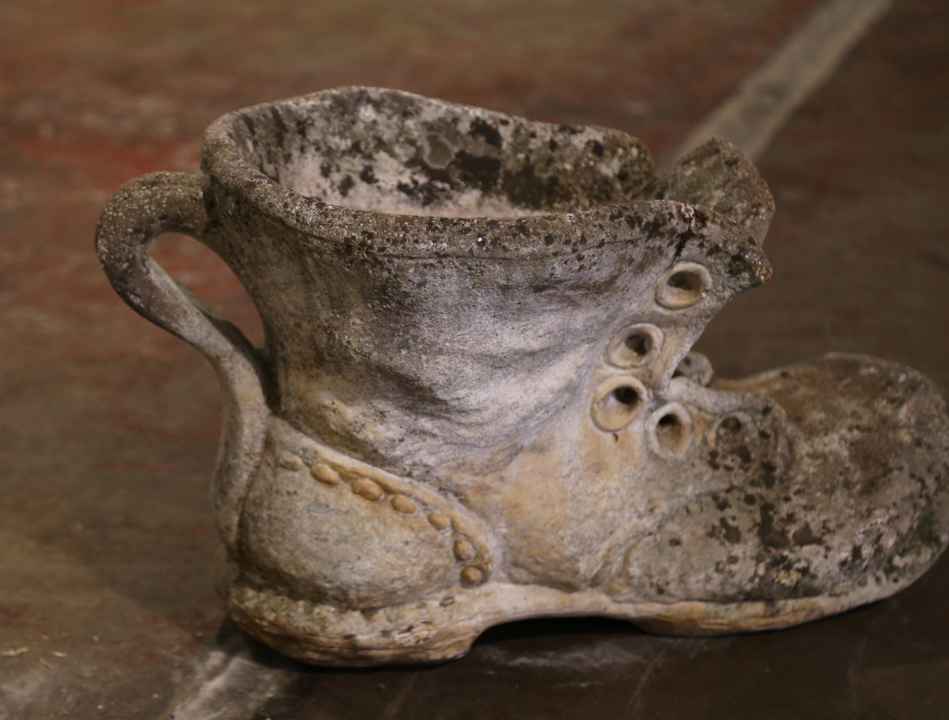 Place this large antique stone boot planter on your patio for a timeless flower display. Crafted in France circa 1920 and built of cast stone, the unusual sturdy jardinière is the shape of a shoe embellished with realistic details in high relief; it