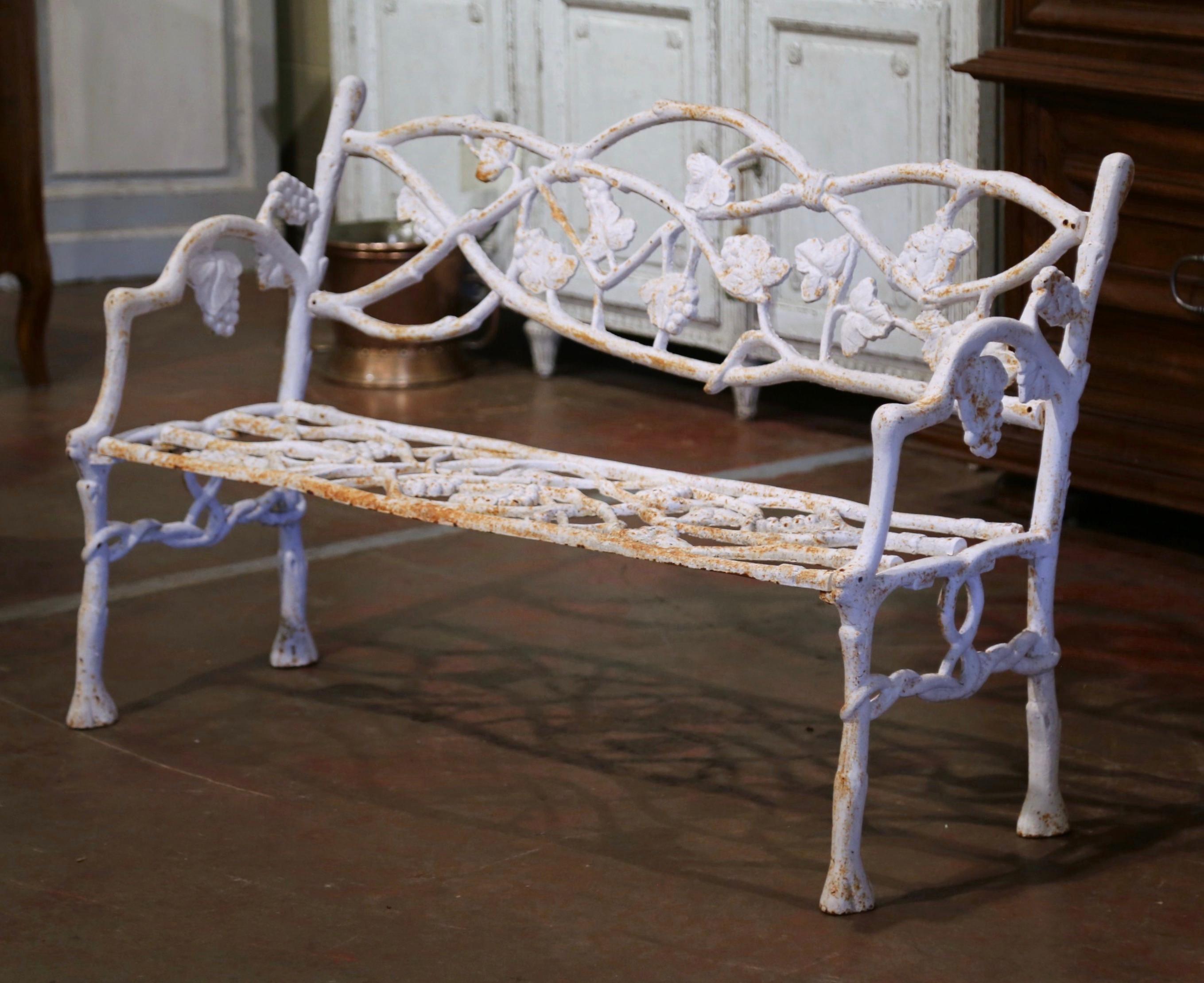 Create extra seating on your patio or in your backyard with this iron bench. Crafted in Normandy France circa 1920, the antique bench stands on carved scrolled painted iron support legs shaped like intertwined tree branches. The back and seat,