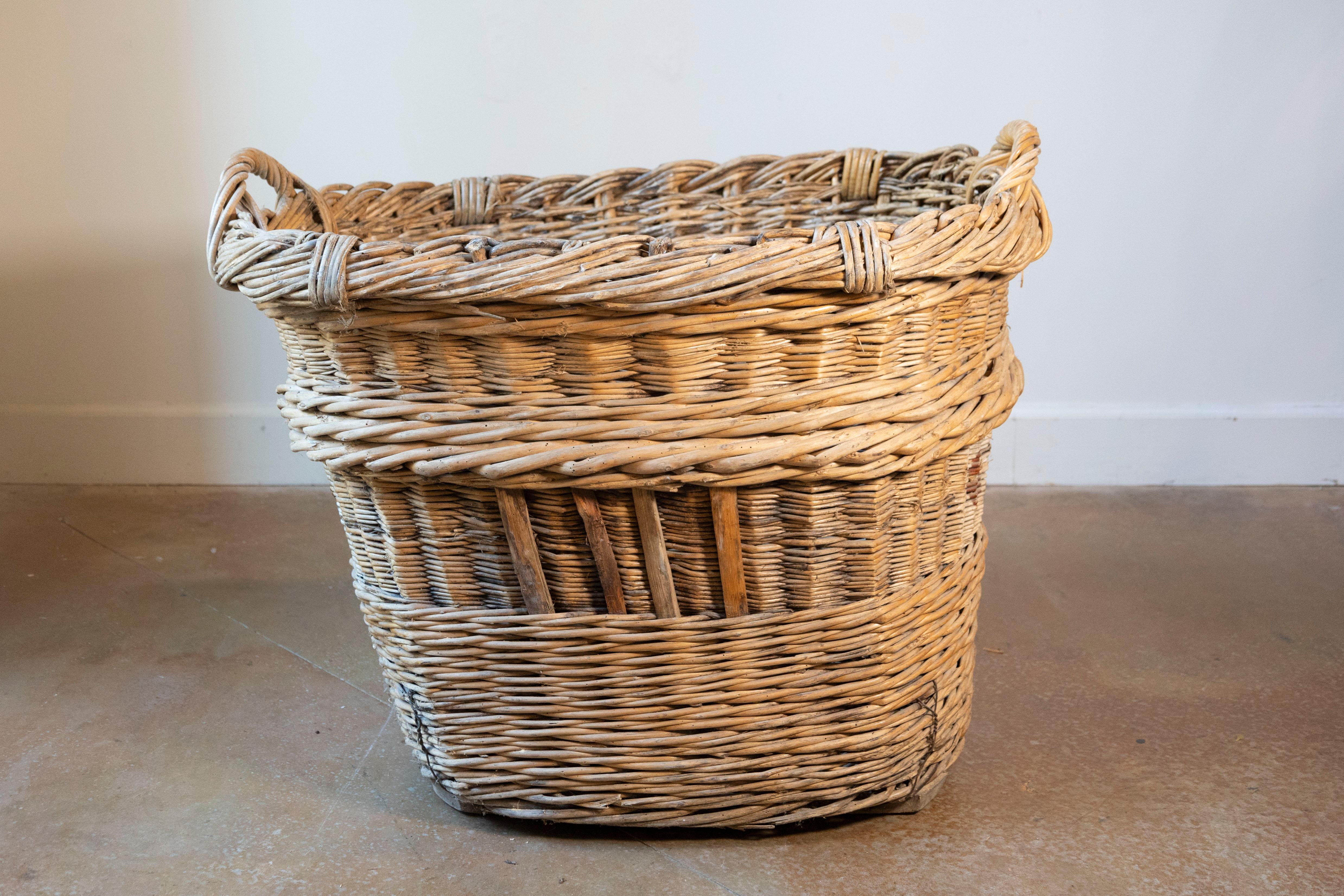 Un cesto per la vendemmia francese dell'inizio del XX secolo, abilmente intrecciato a mano in salice con una presenza robusta e consumata dal tempo. Originario dei vigneti della Francia rurale, questo cestino era un tempo una parte vitale del