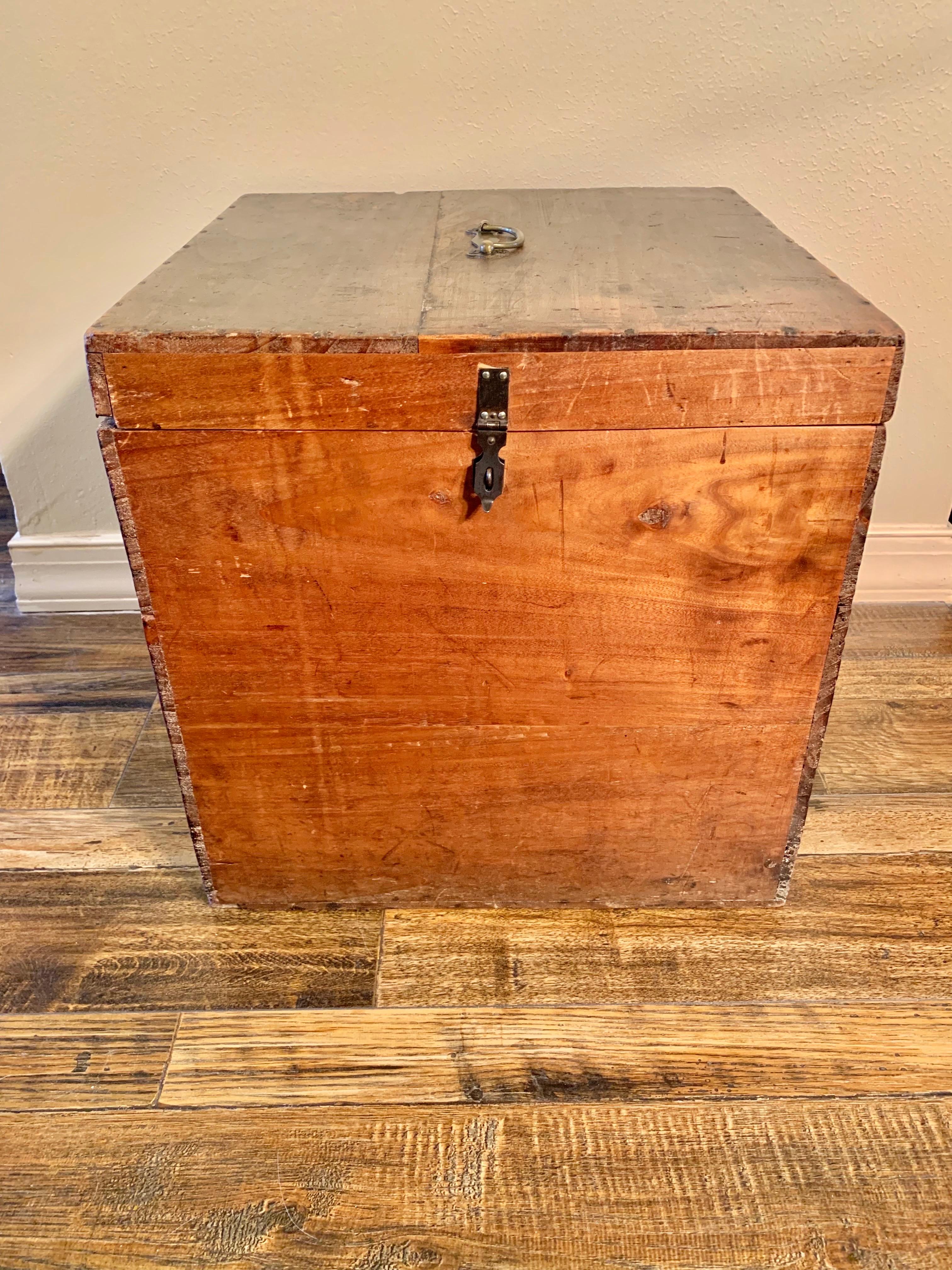 Found in the South of France, this wooden box was handmade in France in the early 20th Century. The piece presents nailhead trim around the edges, a brass handle on the top and a metal hinge locking mechansism. The hinge locking mechanism looks to